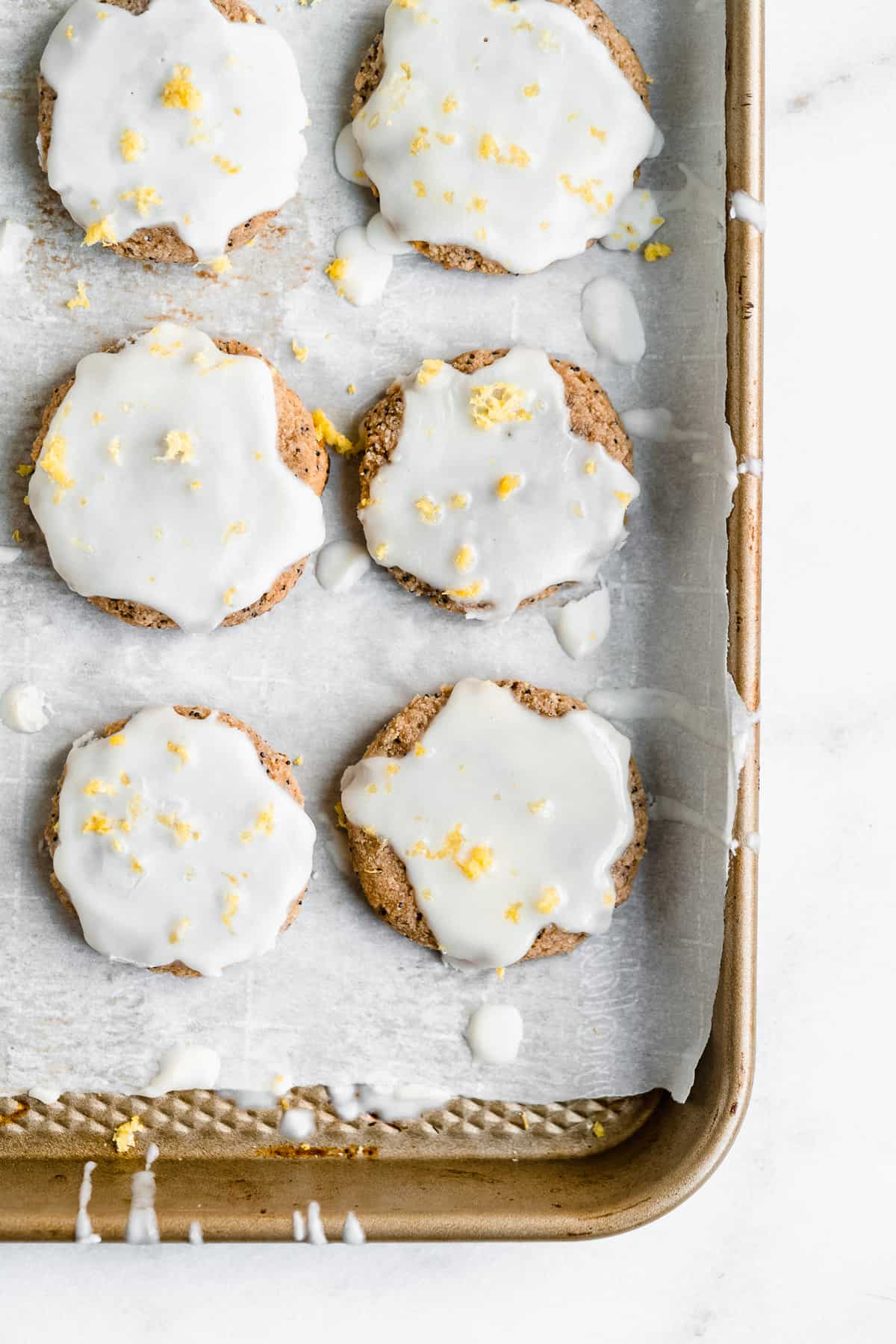 Overhead image of Paleo Lemon Poppy Seed Cookies on white parchment paper on a baking sheet.  