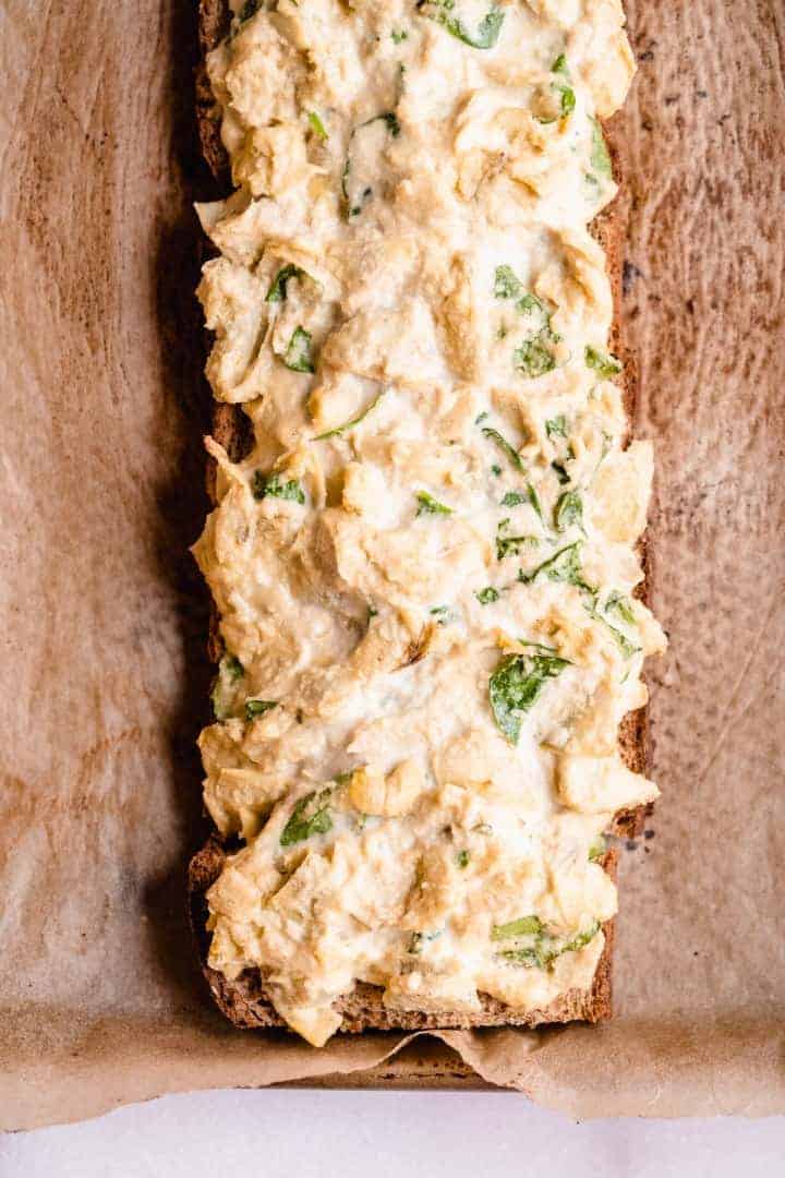 Overhead image of the loaf of Spinach Artichoke Toast laying on parchment paper prior to being cut into sticks.