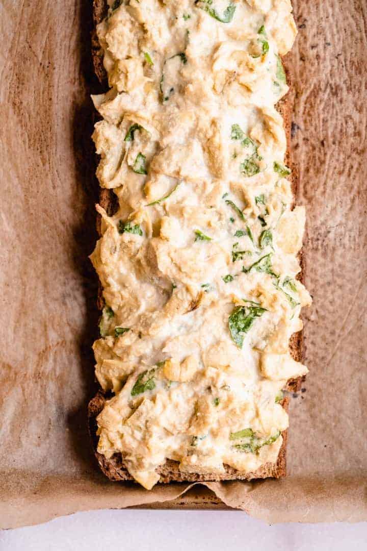 Overhead image of the loaf of Spinach Artichoke Toast laying on parchment paper prior to being cut into sticks.  