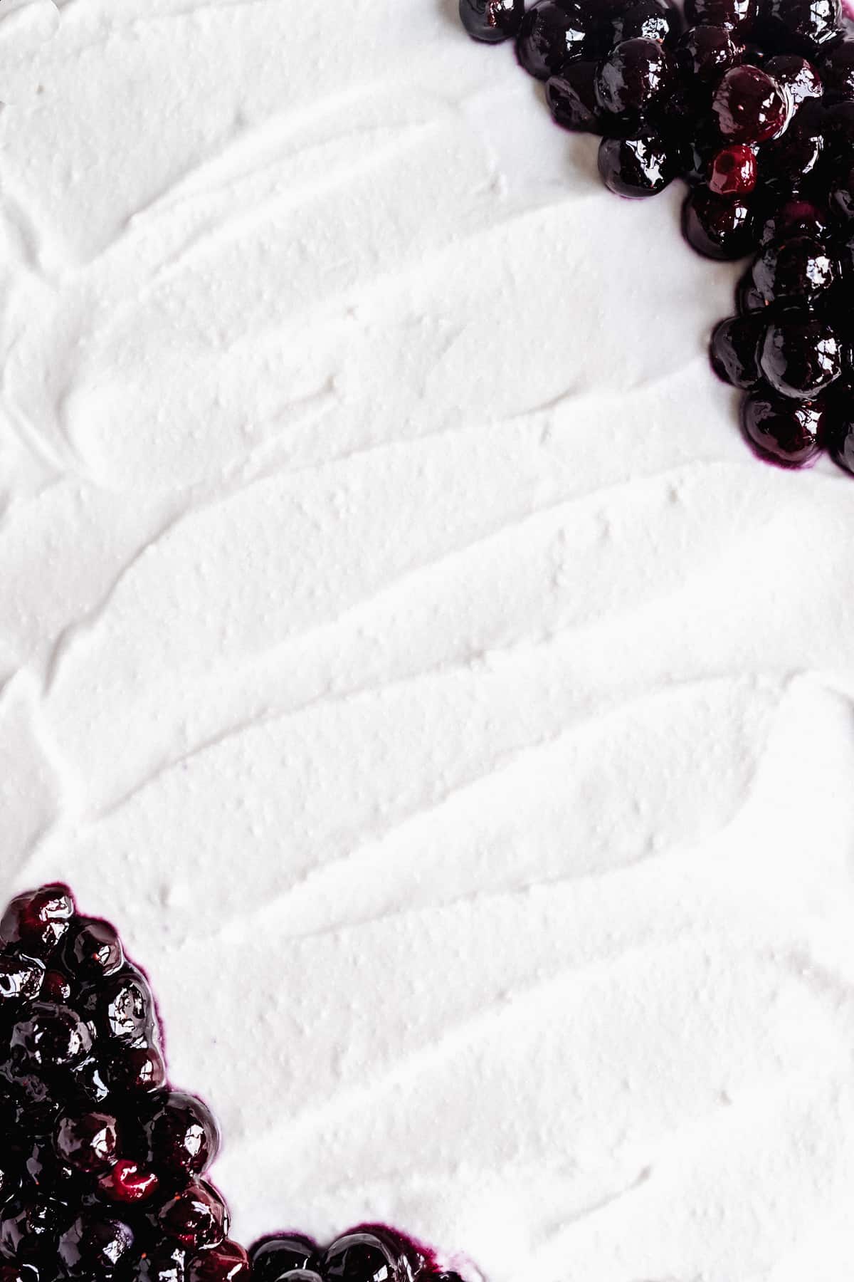 Close up overhead photo of the creamy whipped cream frosting used on top of the Blueberry Vanilla Sheet Cake