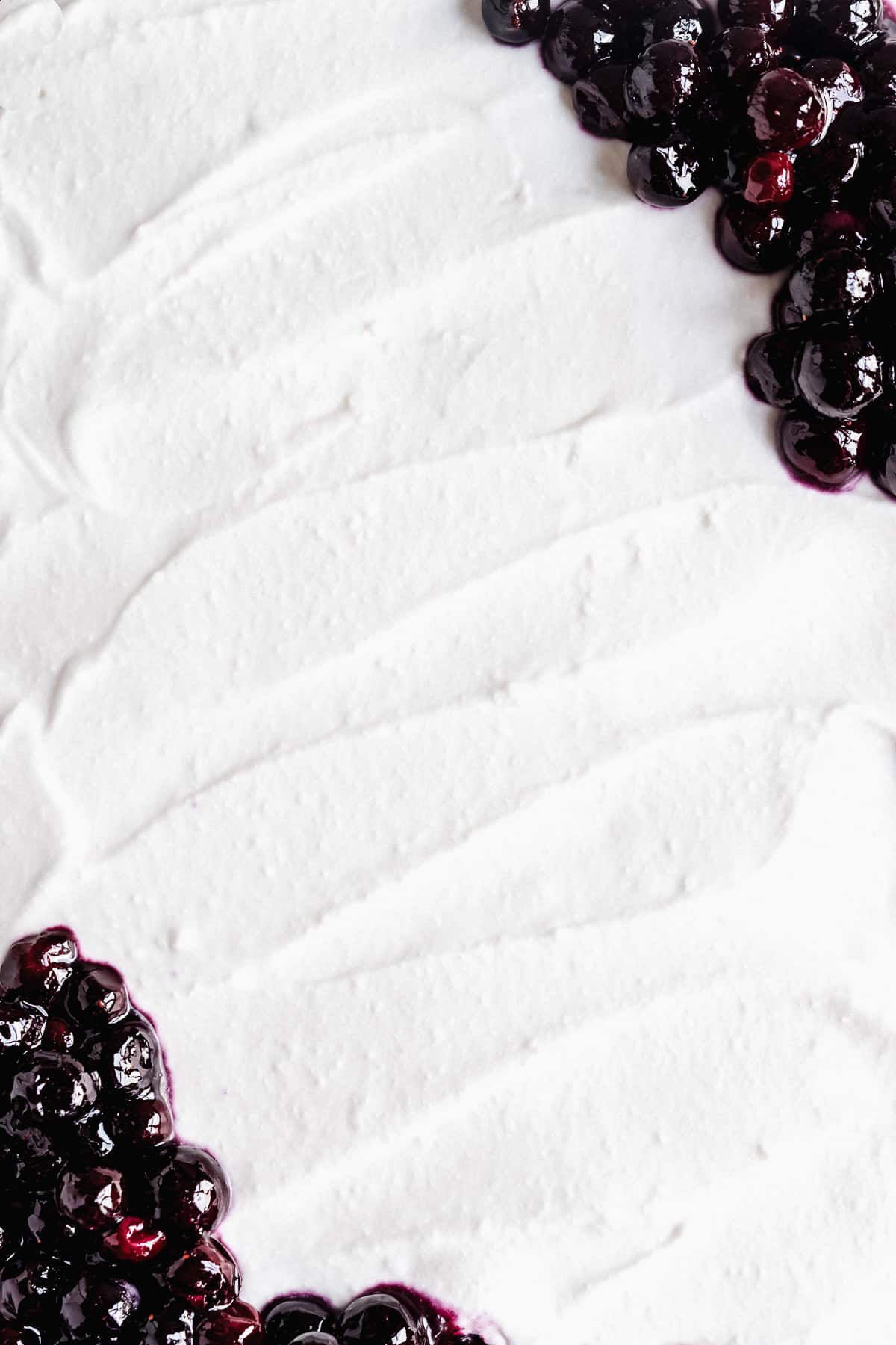 Close up overhead photo of the creamy  whipped cream frosting used on top of the Blueberry Vanilla Sheet Cake