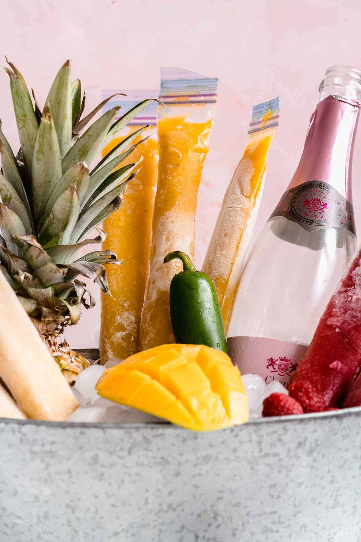 Up close image of ice pops in an ice bucket with fruit.