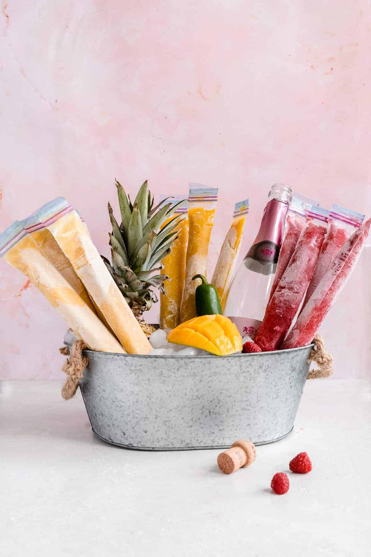 Frozen ice pops standing up in a bucket of ice.