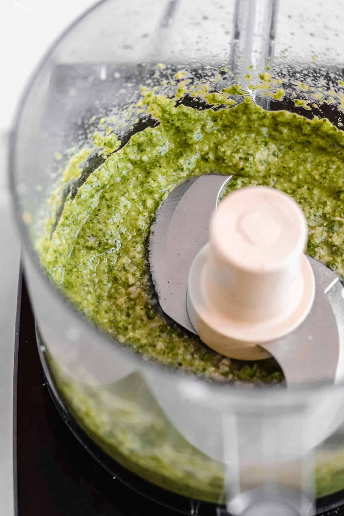 Process photo of the inside of the food processor showing the completed basil pesto sauce.  