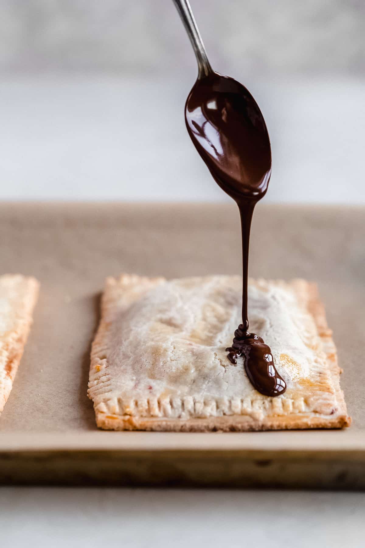 Process photo of the chocolate sauce being drizzled from above onto the top of the tart.