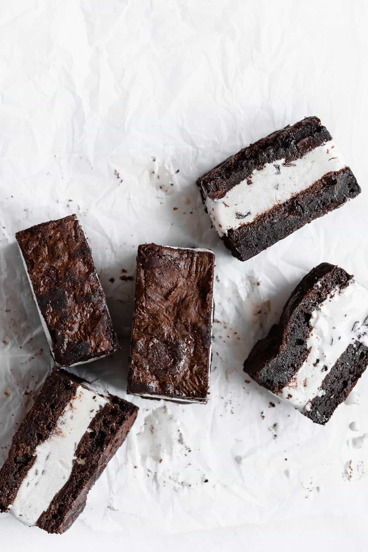 Several Brownie Ice Cream Sandwich squares arranged in white parchment paper.