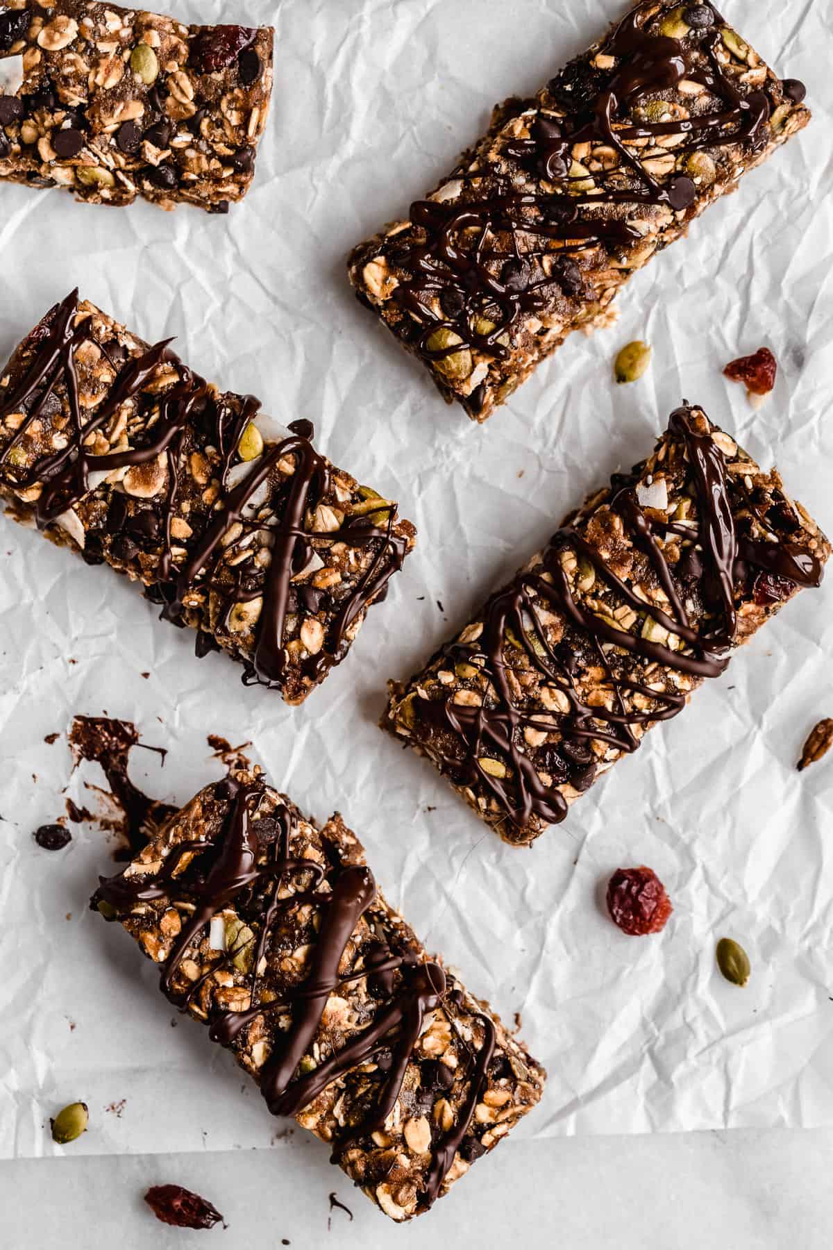 Overhead photo of several Nut-free Chocolate Granola Bars arranged on white parchment paper.