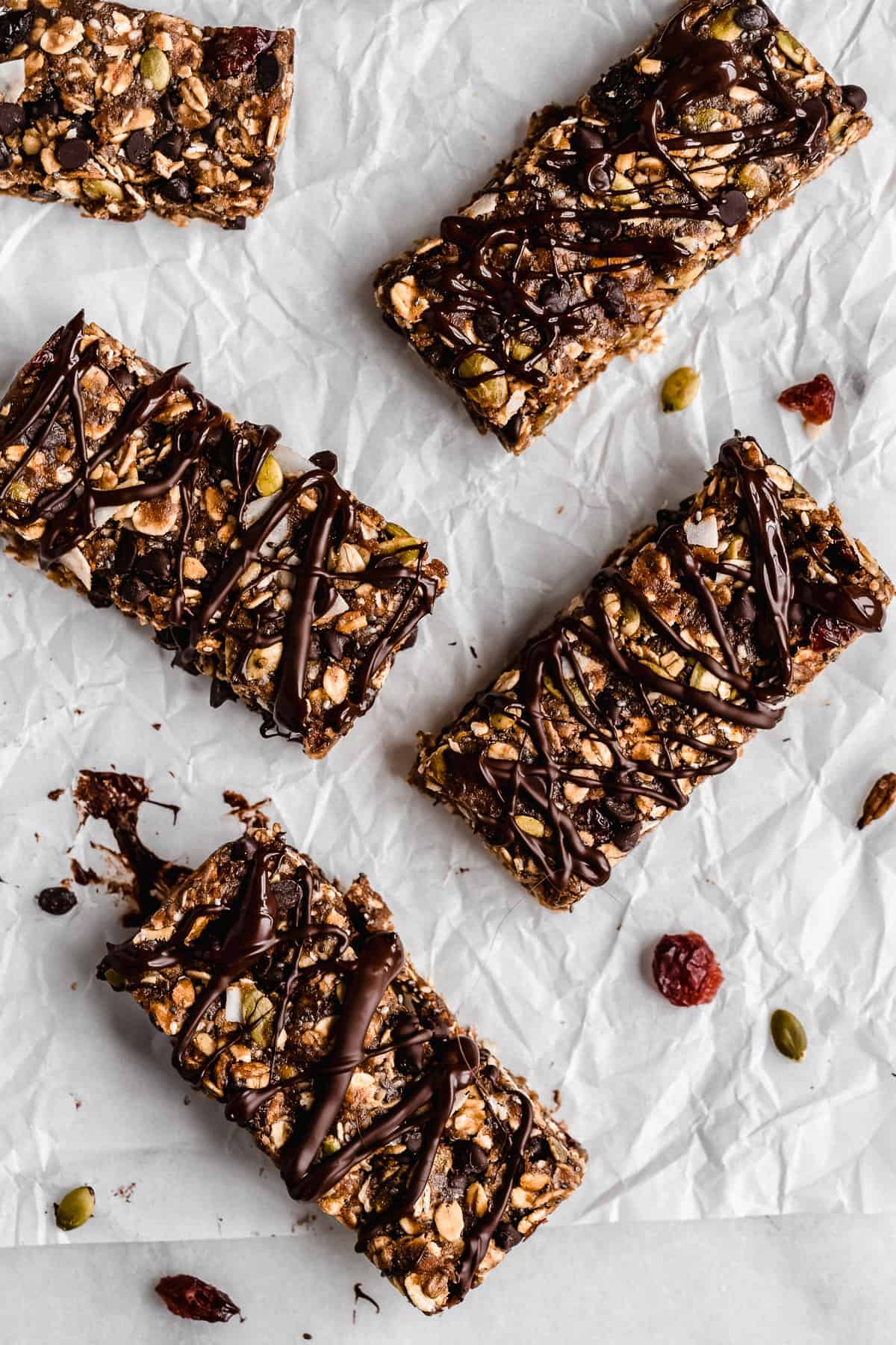 Overhead photo of several Nut-free Chocolate Granola Bars arranged on white parchment paper.  