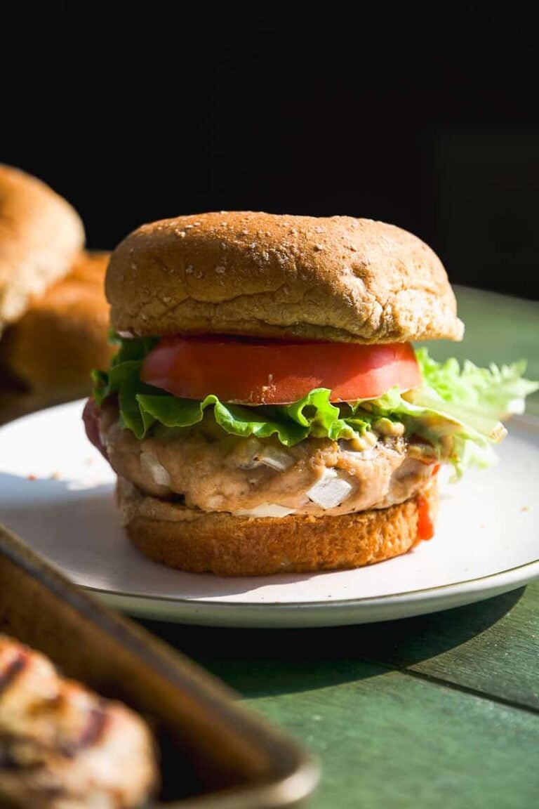 Turkey burgers on a plate with toppings.