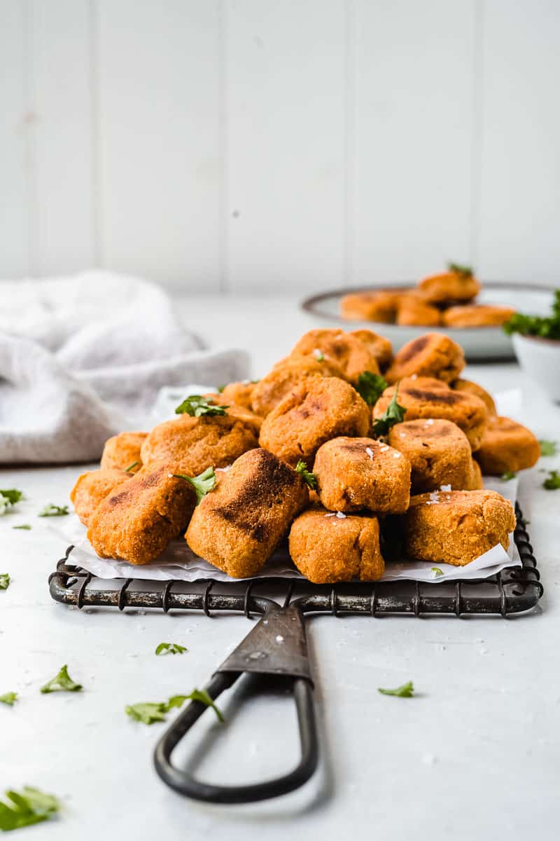 Pile of sweet potato tots on a wire rack.