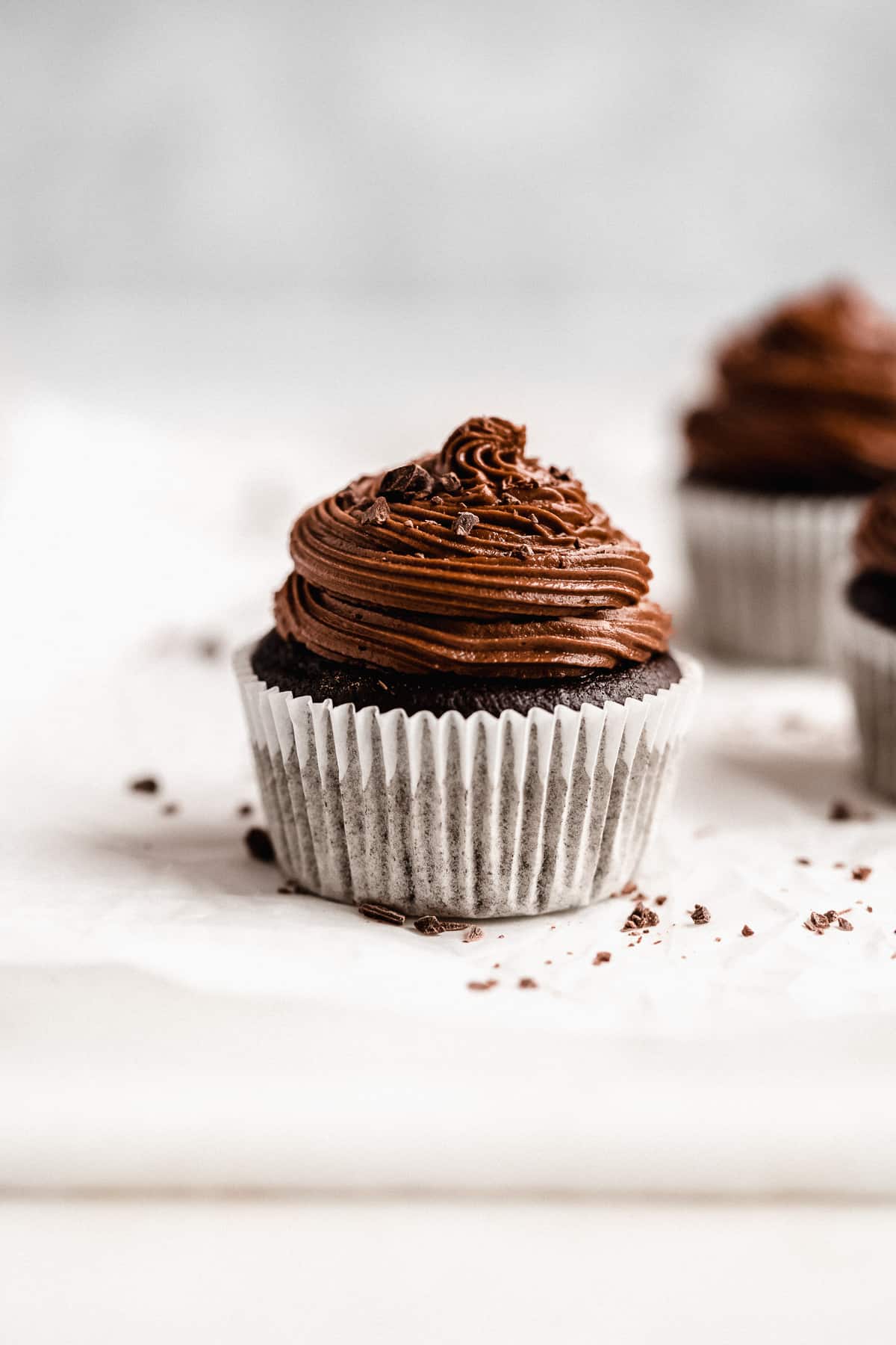 Side view close up photo of a single Gluten-free Chocolate Cupcake with Chocolate Ganache Frosting.