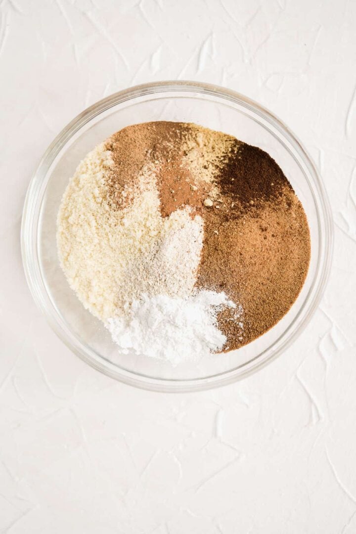 Overhead photo of a large clear bowl with all of the dry ingredients used in this recipe.