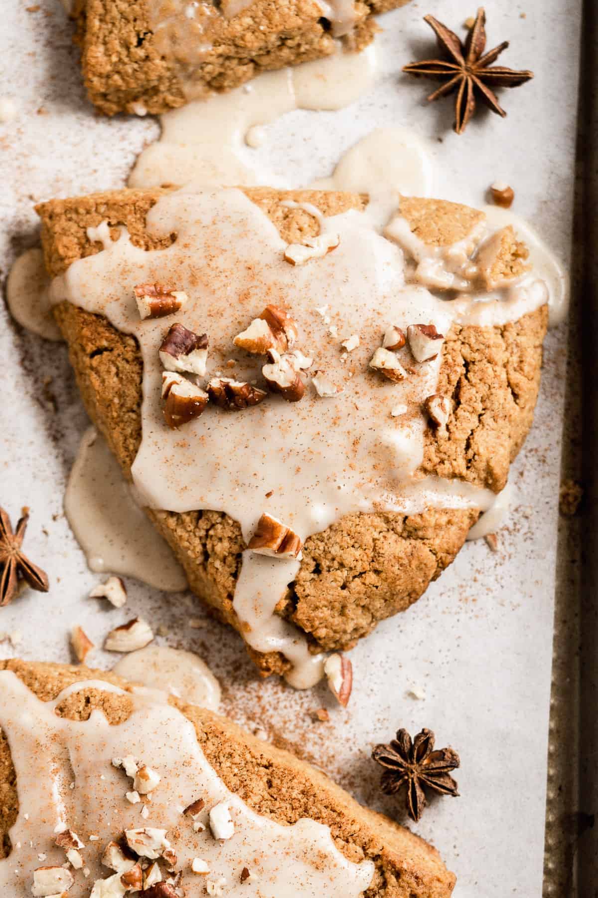 Close up photo of a freshly baked and glazed Chai Spiced Gluten-free Vegan Scone on a baking sheet.  