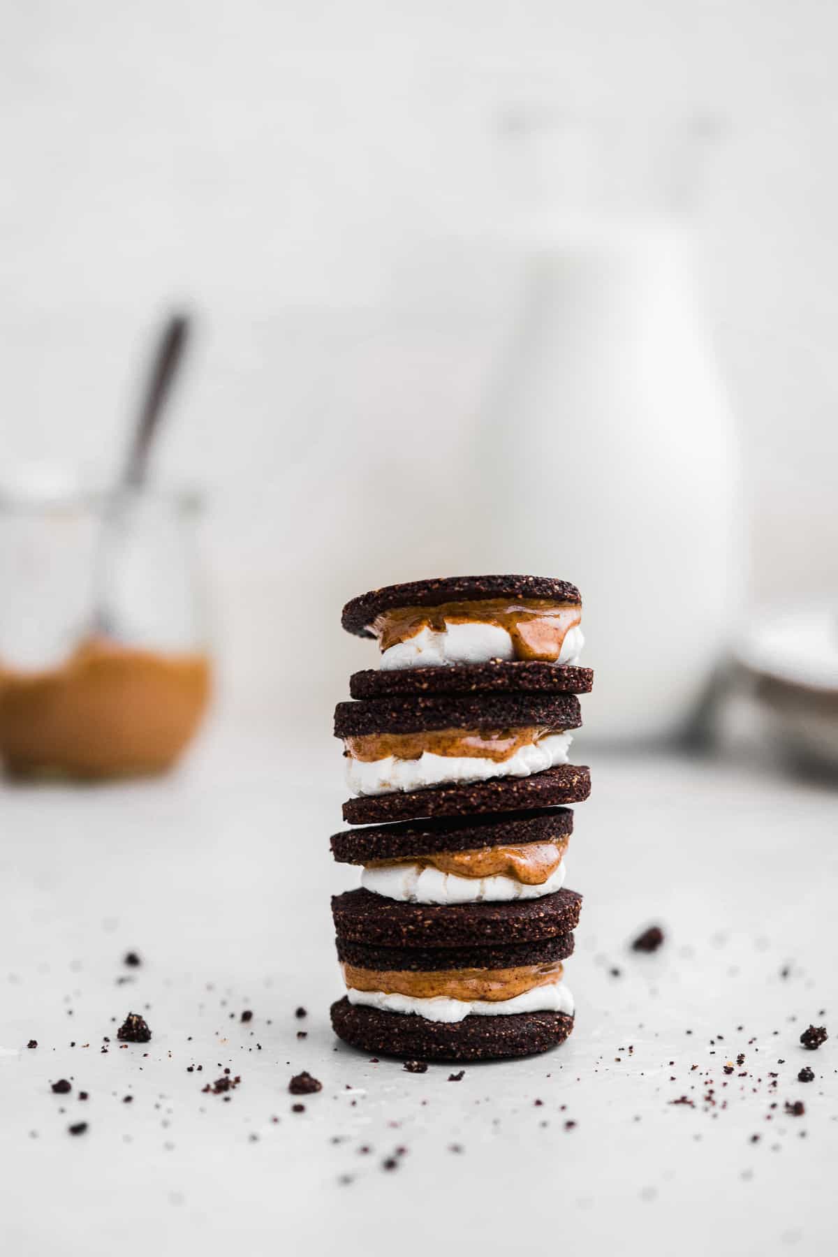 Side view photo of a stack of four gluten free Oreo cookies!  Almond butter is oozing down the side of the marshmallow center.