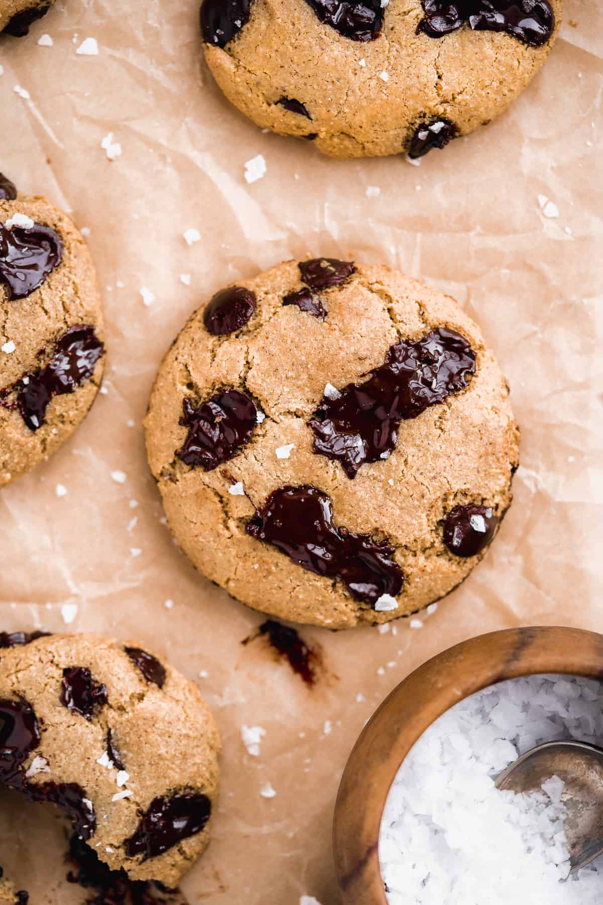 Close up photo of freshly baked Almond Butter Chocolate Chip Cookies on parchment paper.
