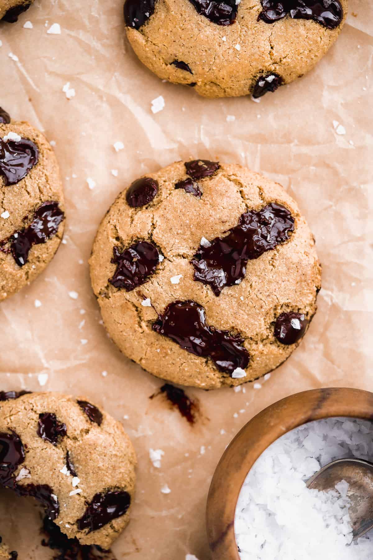 Close up photo of freshly baked Almond Butter Chocolate Chip Cookies on parchment paper.  