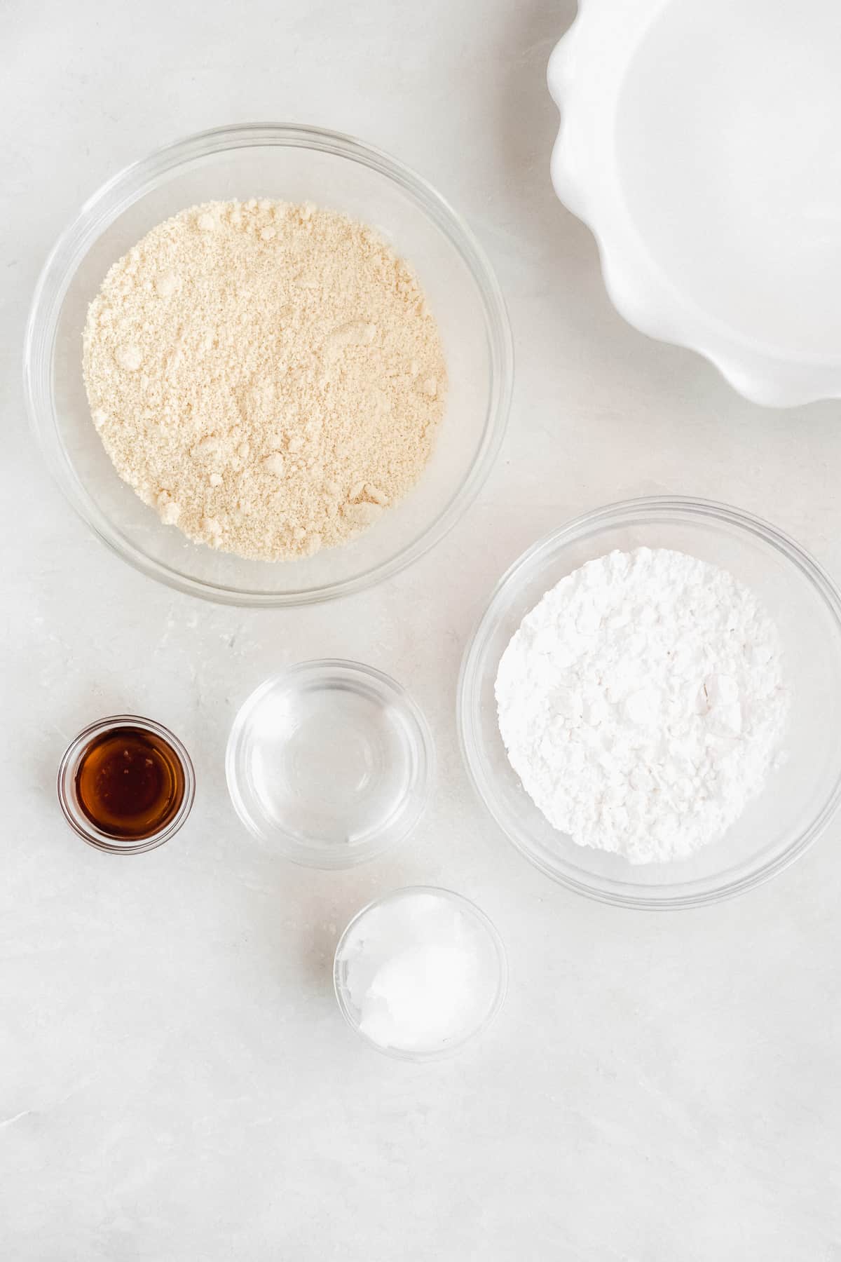 Overhead view of ingredients needed for pie crust arranged in separate clear bowls .