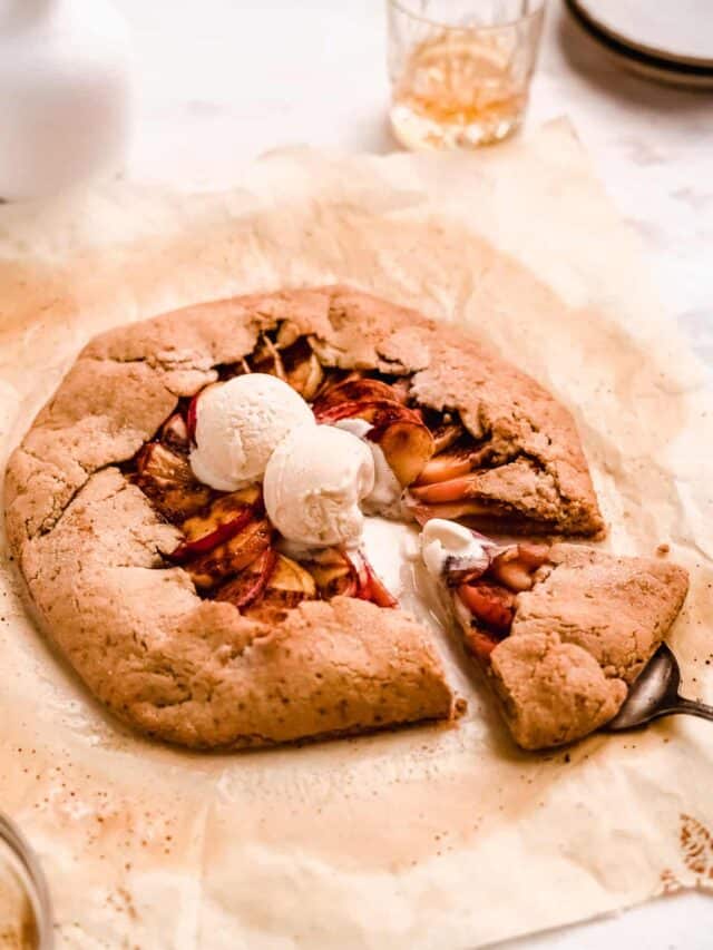 Bourbon Apple Galette topped with ice cream with a slice being taken.