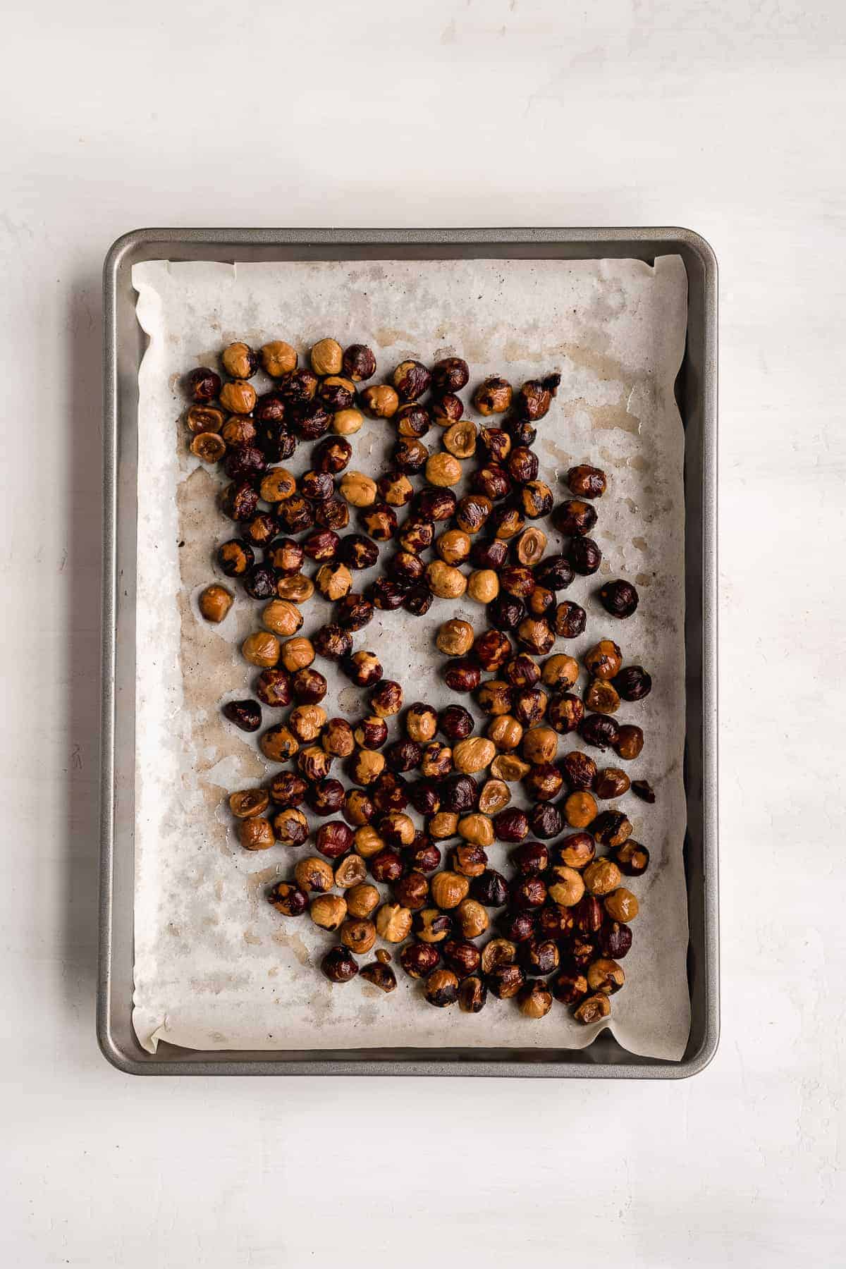 Roasted hazelnuts on a baking pan.