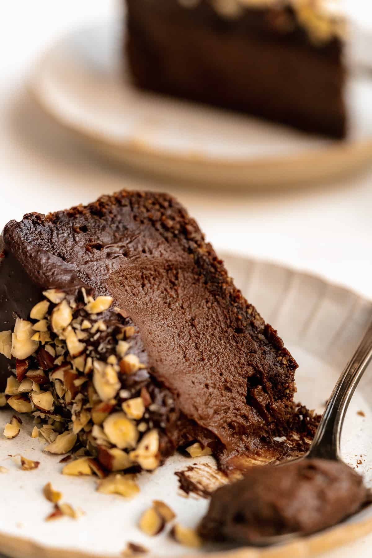 Close up view of a single slice of Chocolate Toasted Hazelnut Cheesecake on a plate.  