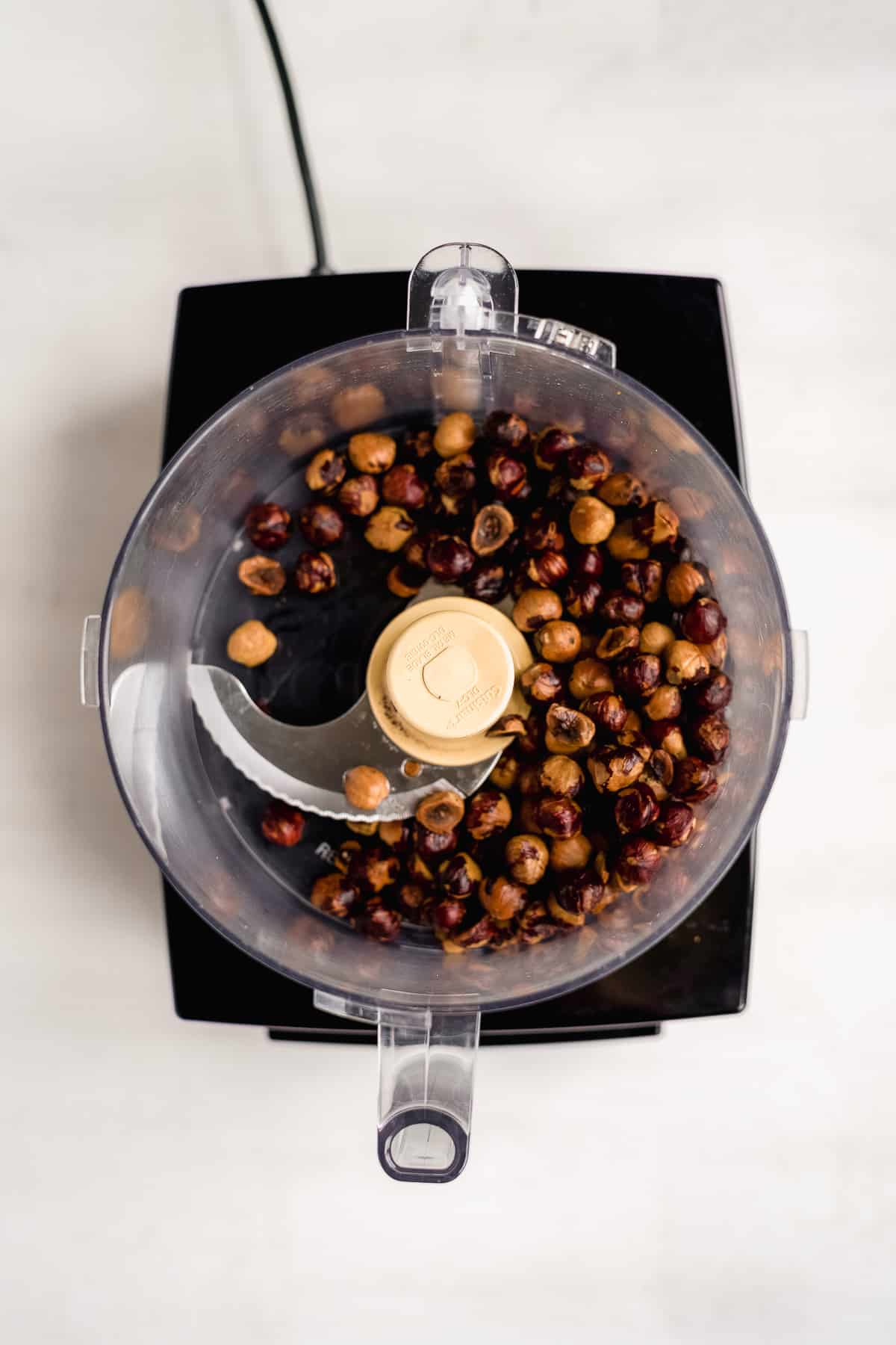 Hazelnuts in a food processor about to be blended.