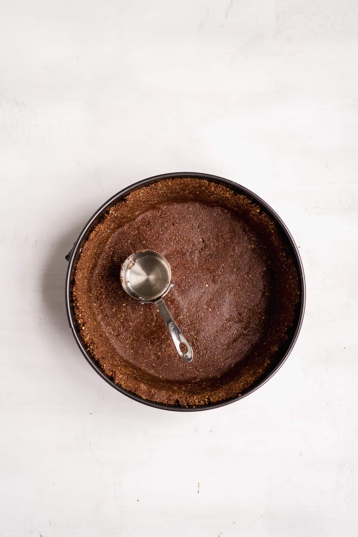 Chocolate oat crust pressed into a spring form pan.