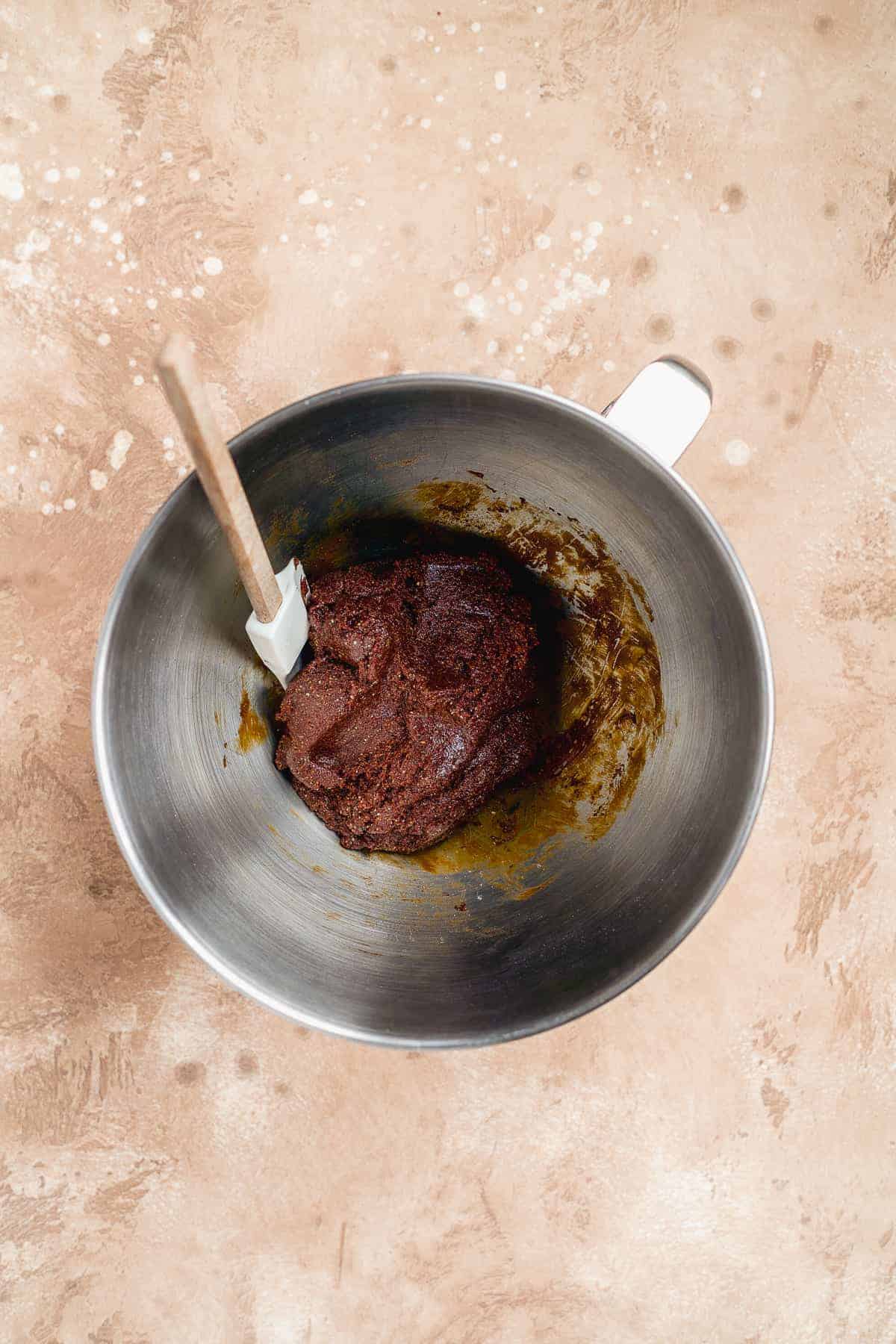 Metal bowl with ginger snap cookie dough inside.