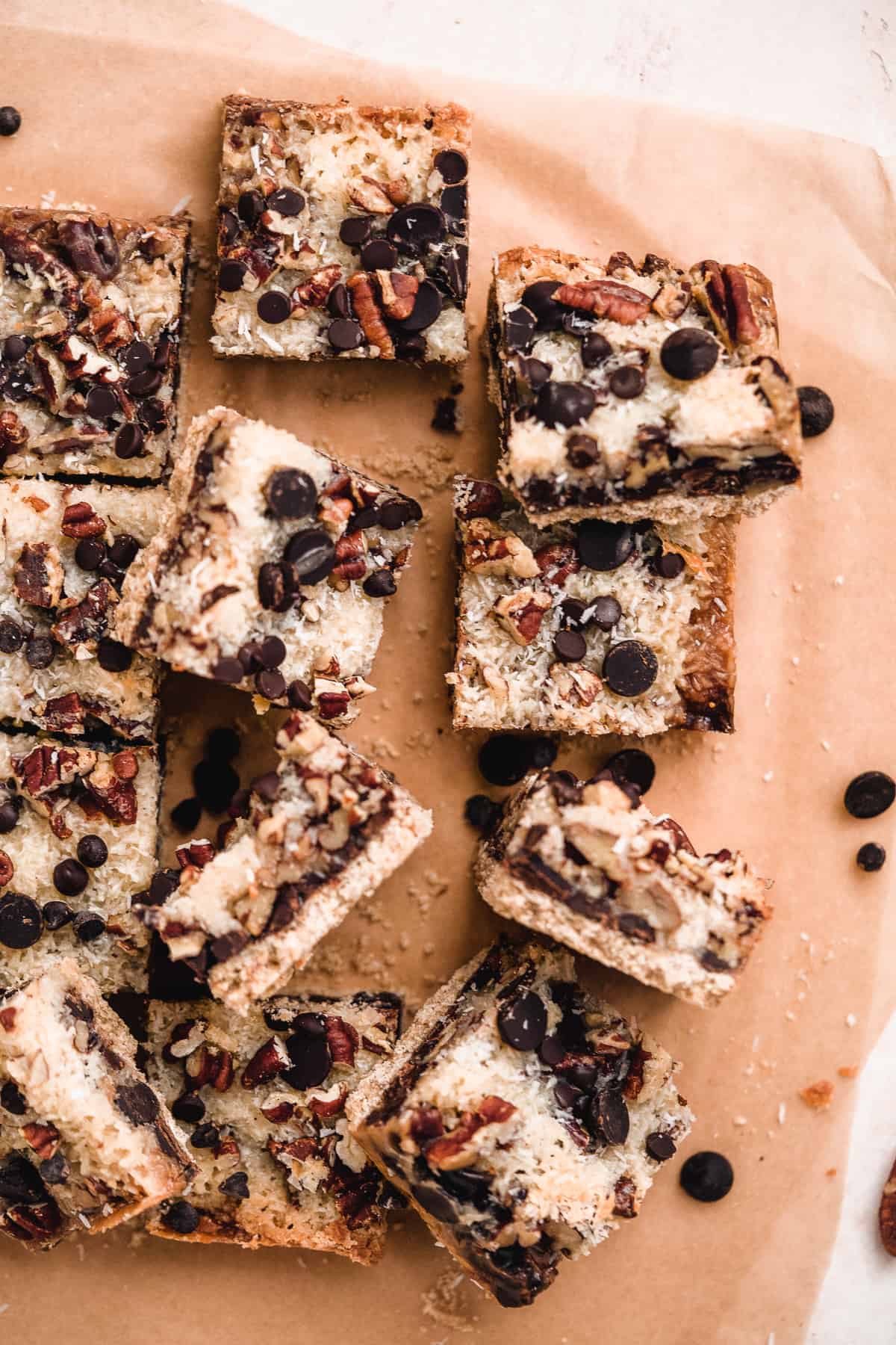Close up view of baked Toasted Oat Seven Layer Magic Cookie Bars cut into squares and separated to show side and overhead views of the delicious treats.