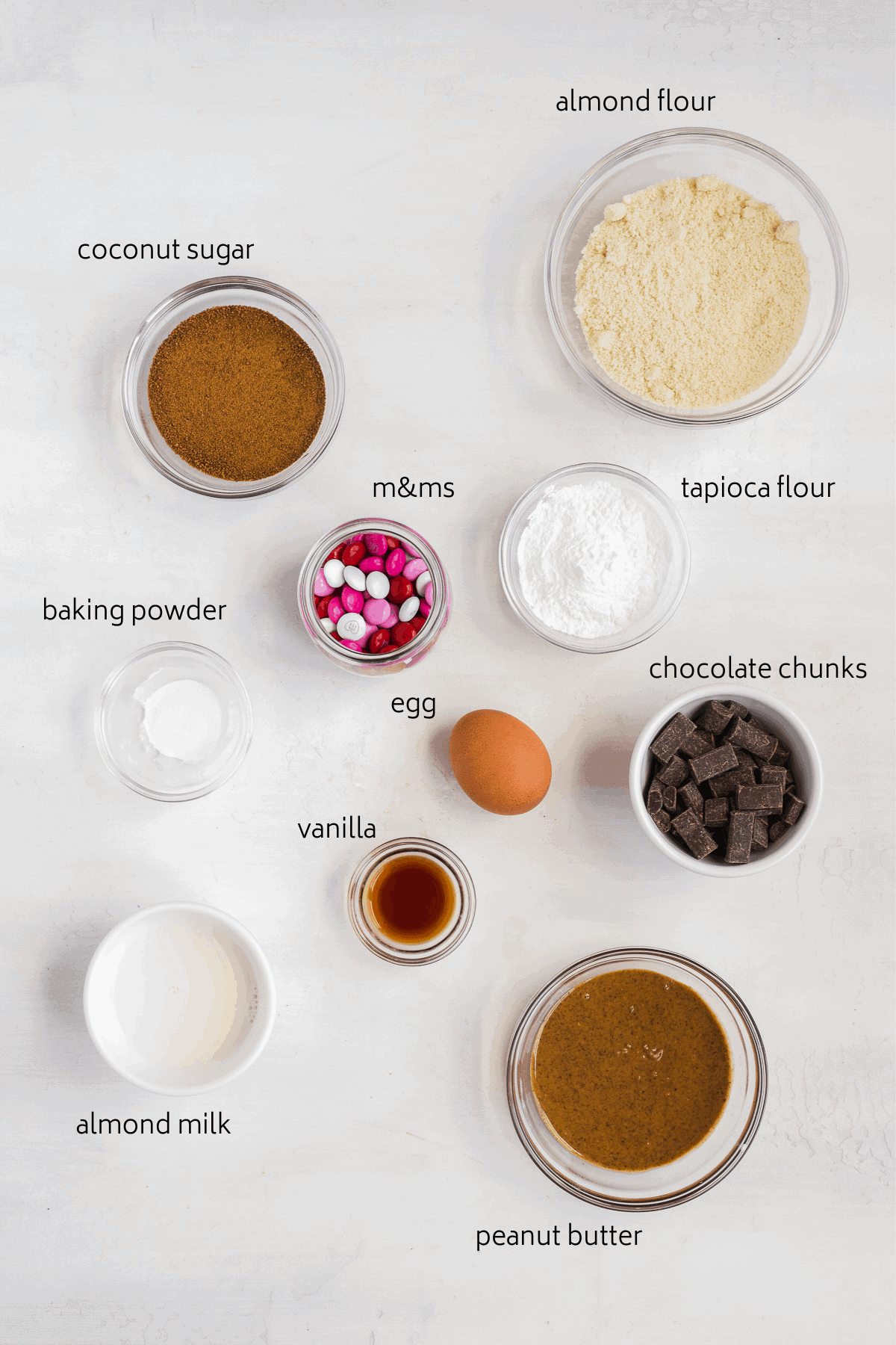 Image of ingredients labeled in glass bowls on a white surface.