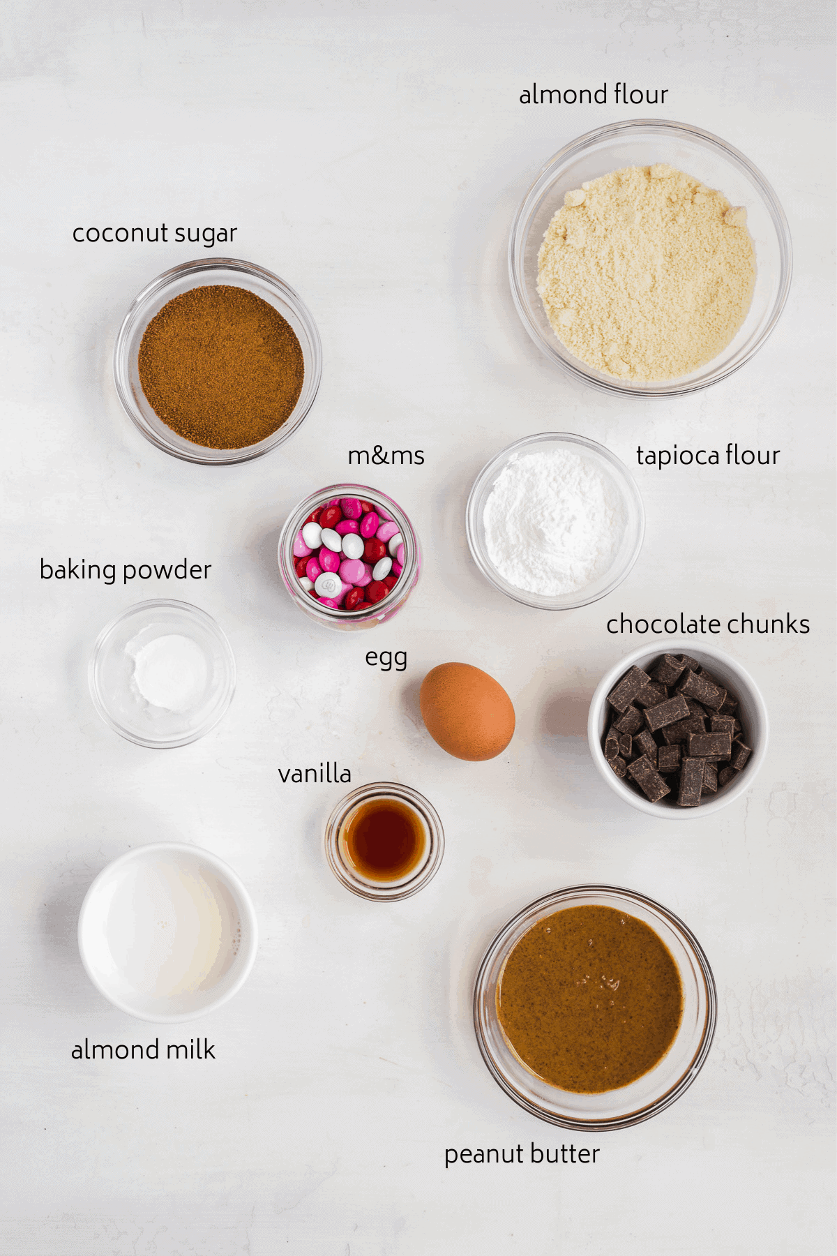 Image of ingredients labeled in glass bowls on a white surface. 