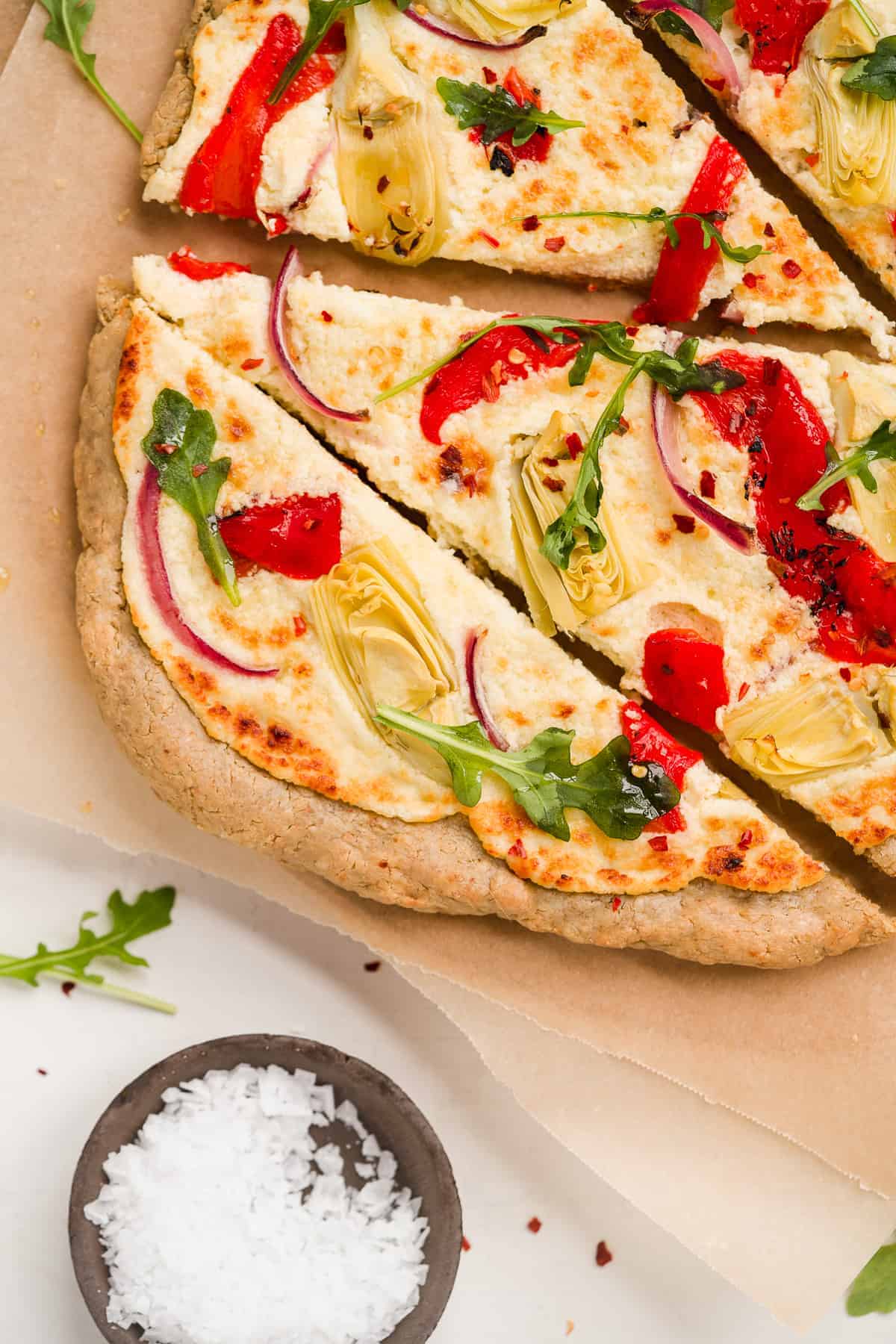 Baked pizza on brown paper with red peppers and sea salt.