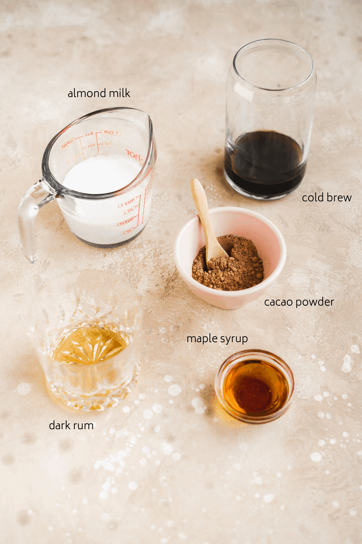 Espresso martini ingredients on a brown surface with labels in black.