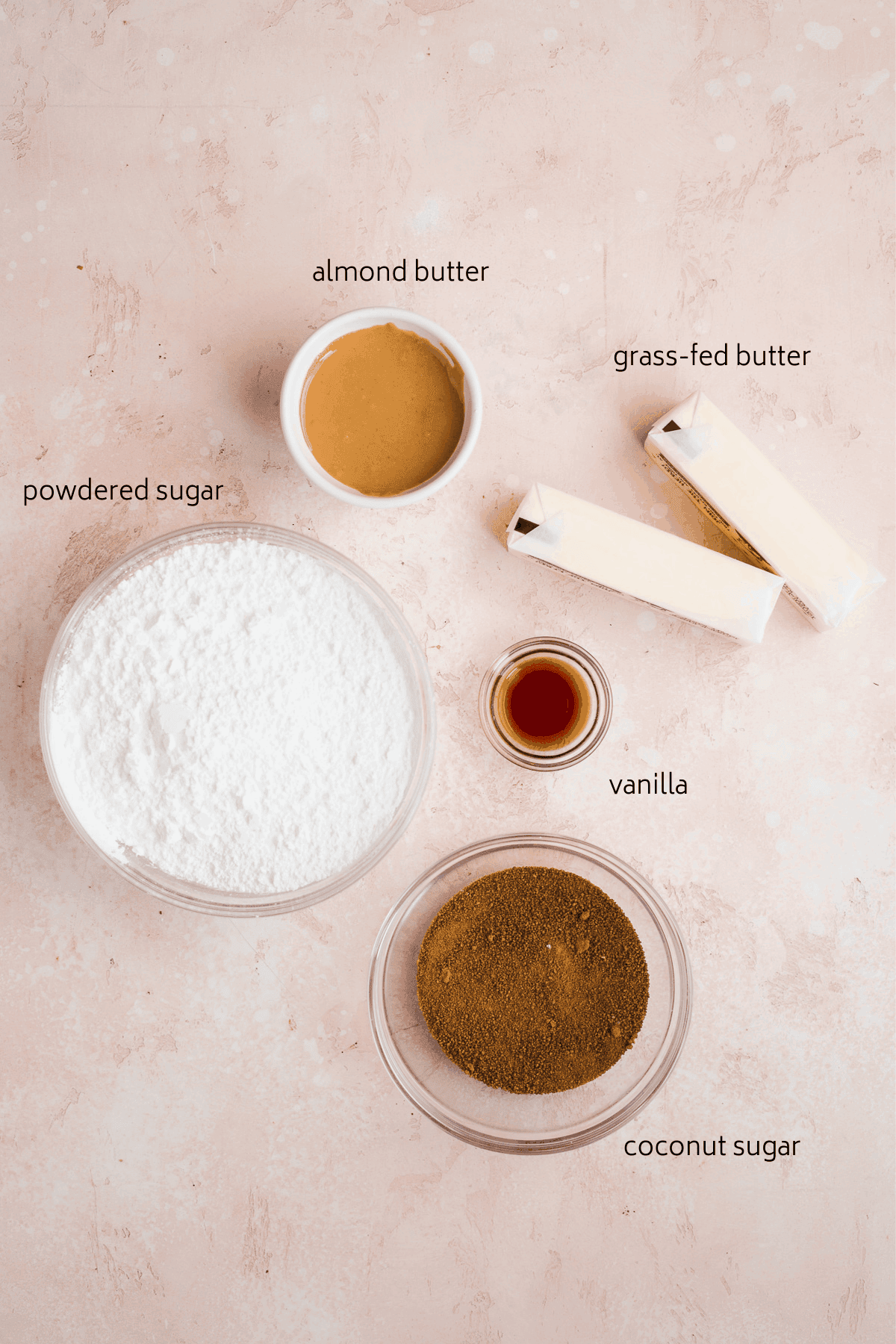 Icing ingredients with labels on a pink surface.