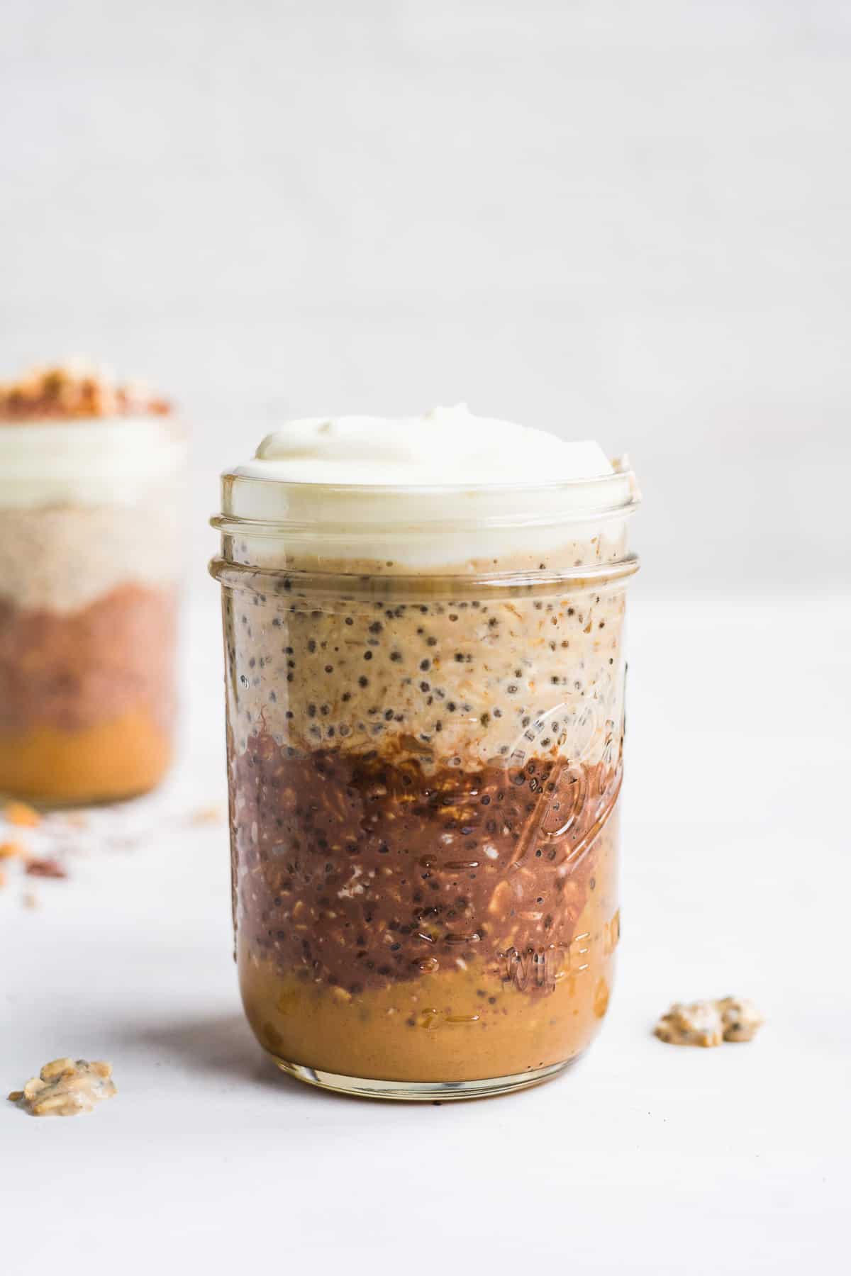 A jar with layers of oats and yogurt on top.