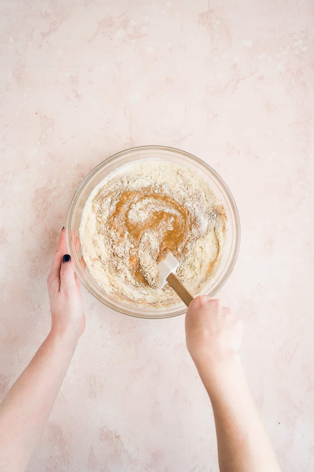 Person whisking dry cookie dough cake ingredients into cake batter.