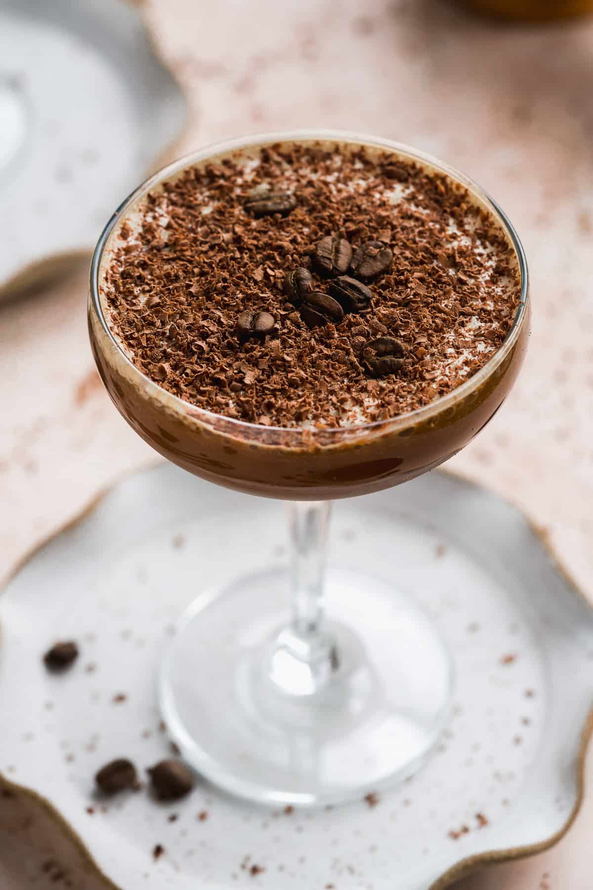 Chocolate drink in a cocktail glass with chocolate shavings and espresso beans.