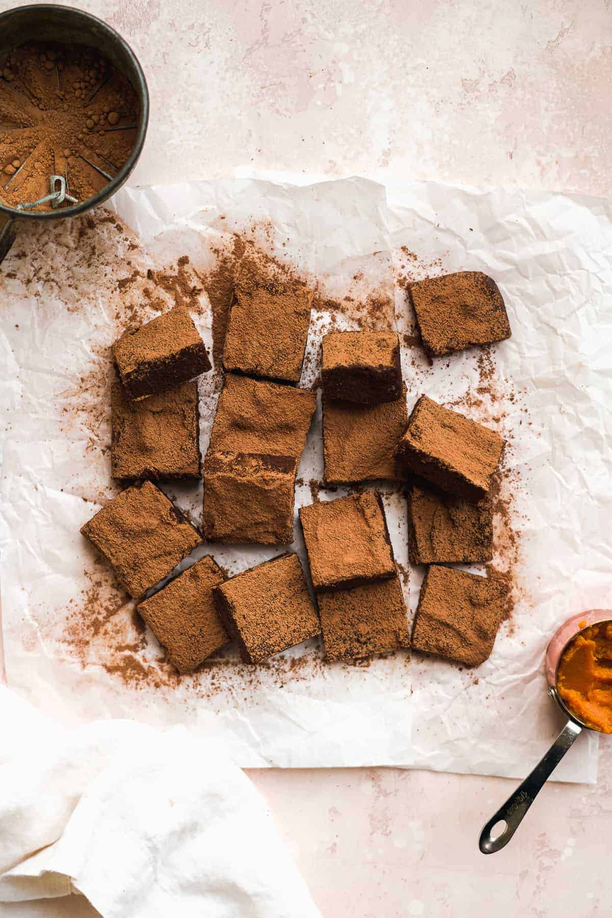 Overhead view of a batch of brownies sliced into squares and scattered around.