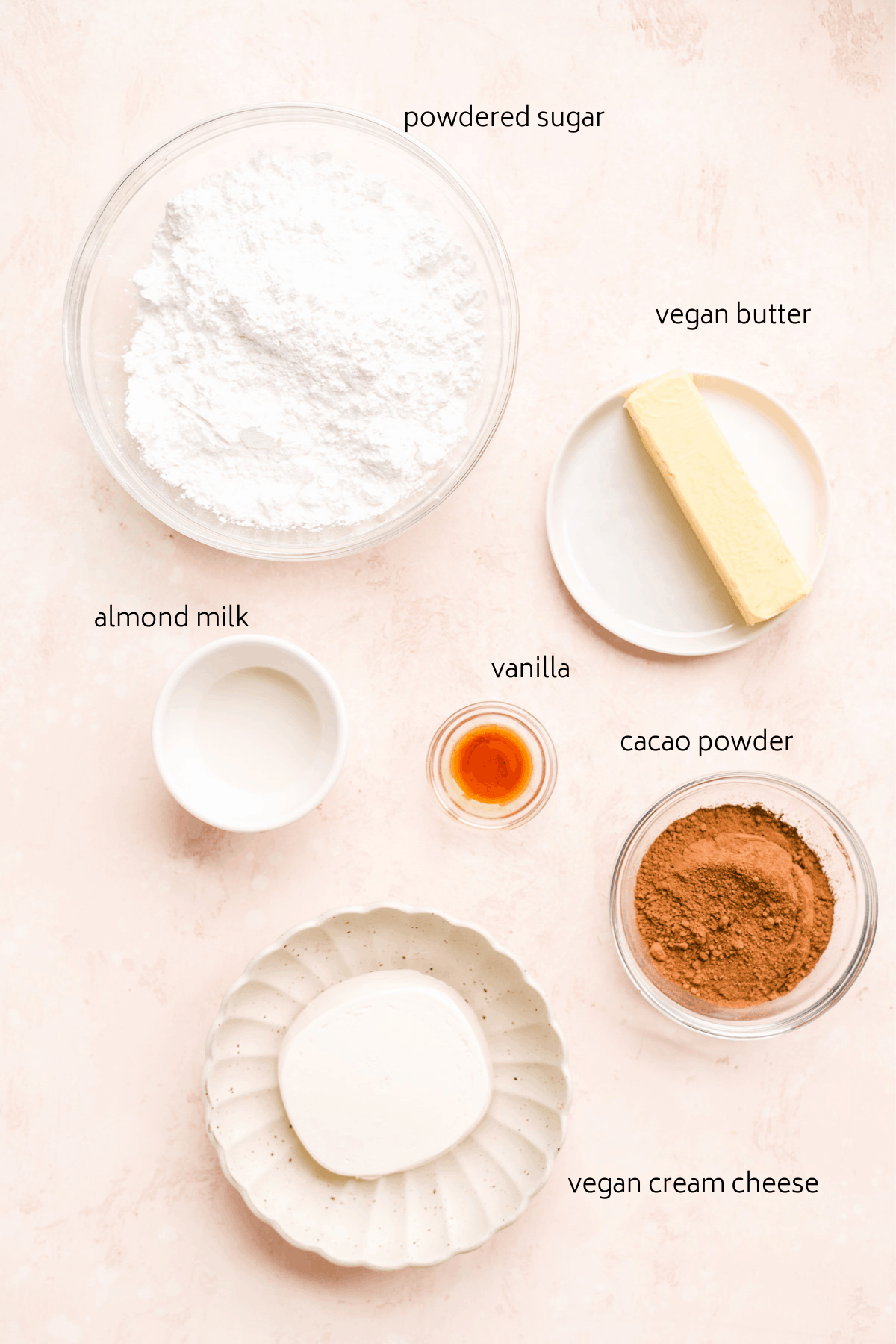 Image of ingredients on surface with labels including powdered sugar, vegan butter, cacao powder, etc.