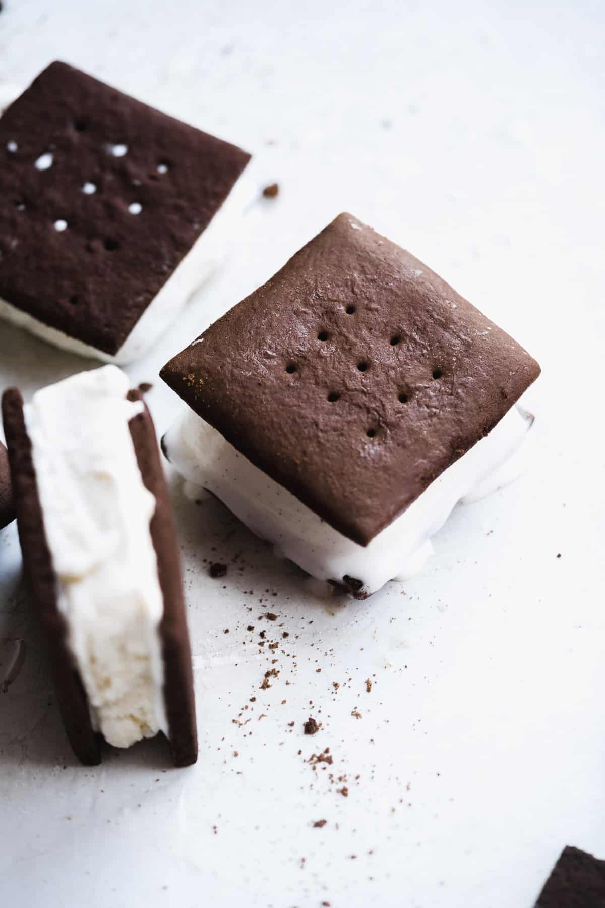 Chocolate ice cream sandwich with ice cream melting off the sides and one flipped upwards.