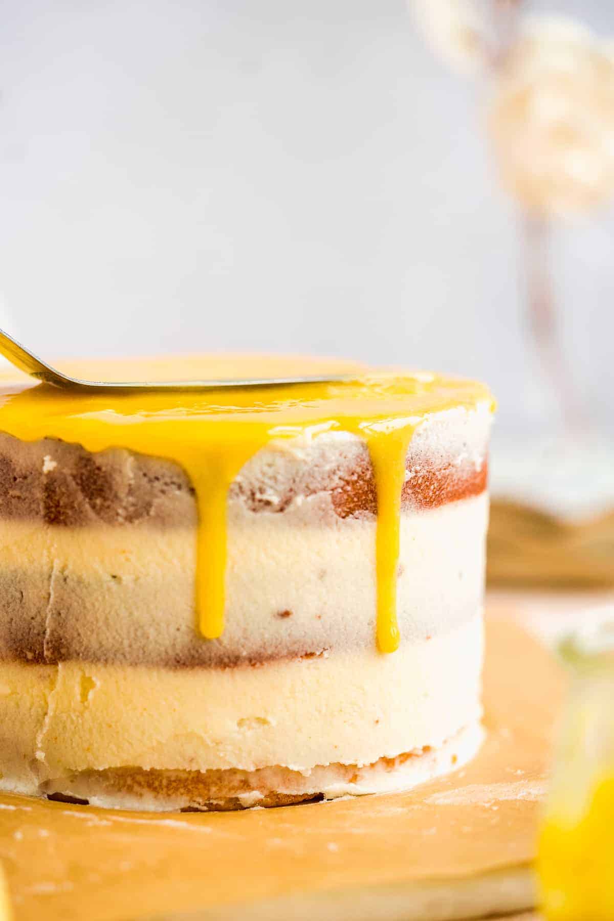 Lemon curd being spread on top of a cake.