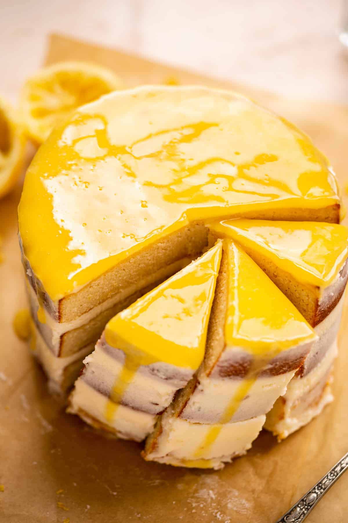 Cake with layer of lemon curd on top and three slices leaning against each other.