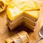 Lemon cake on parchment paper with slices cut out.
