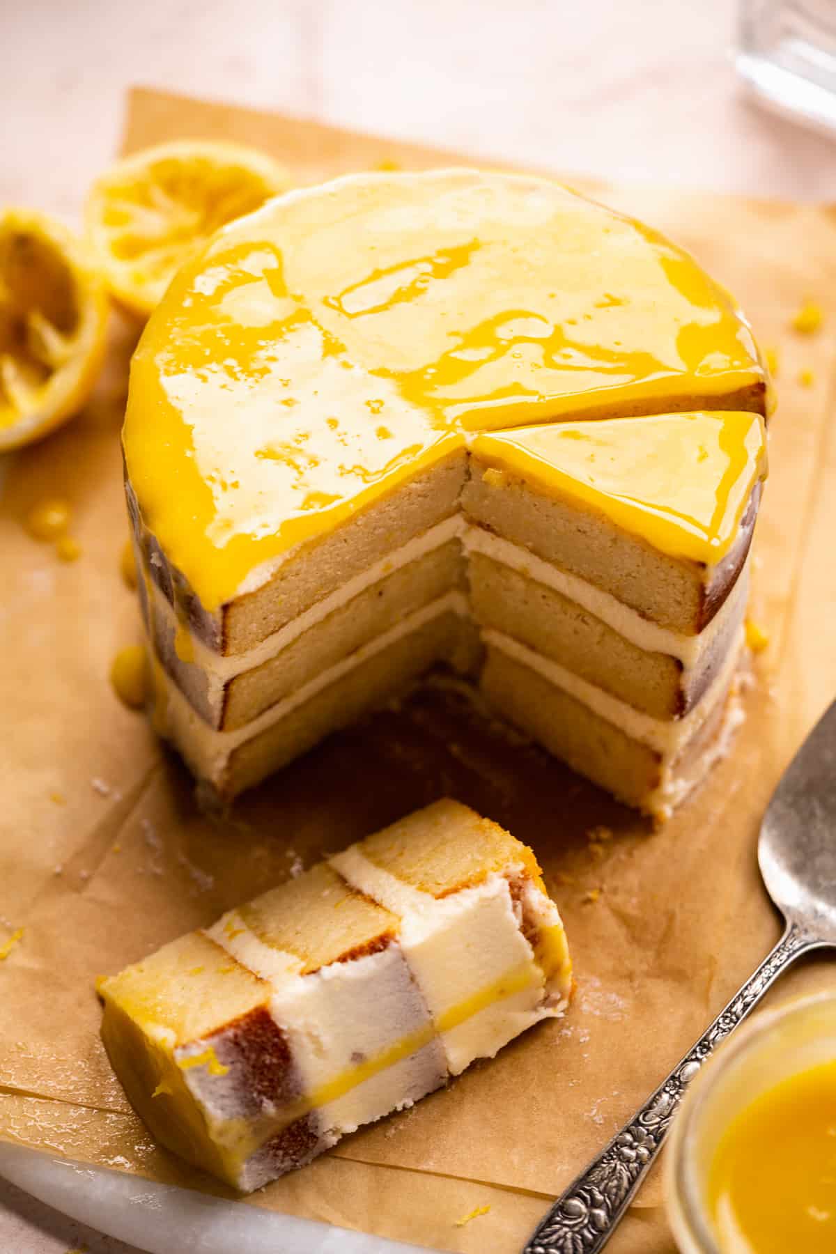 Lemon cake sliced with pieces scattered on surface and drizzle on top.