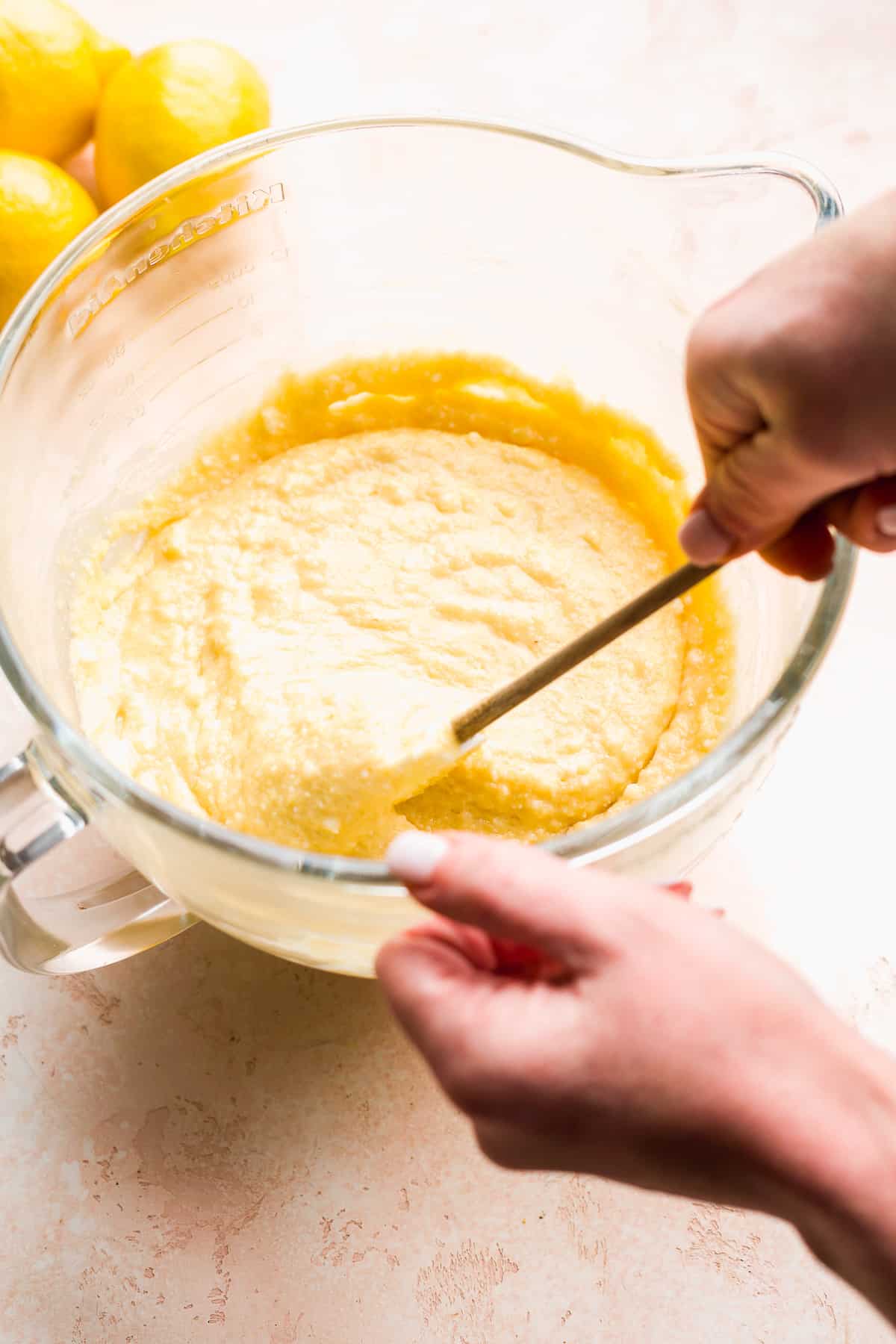 Person mixing lemon cake batter in a bowl.