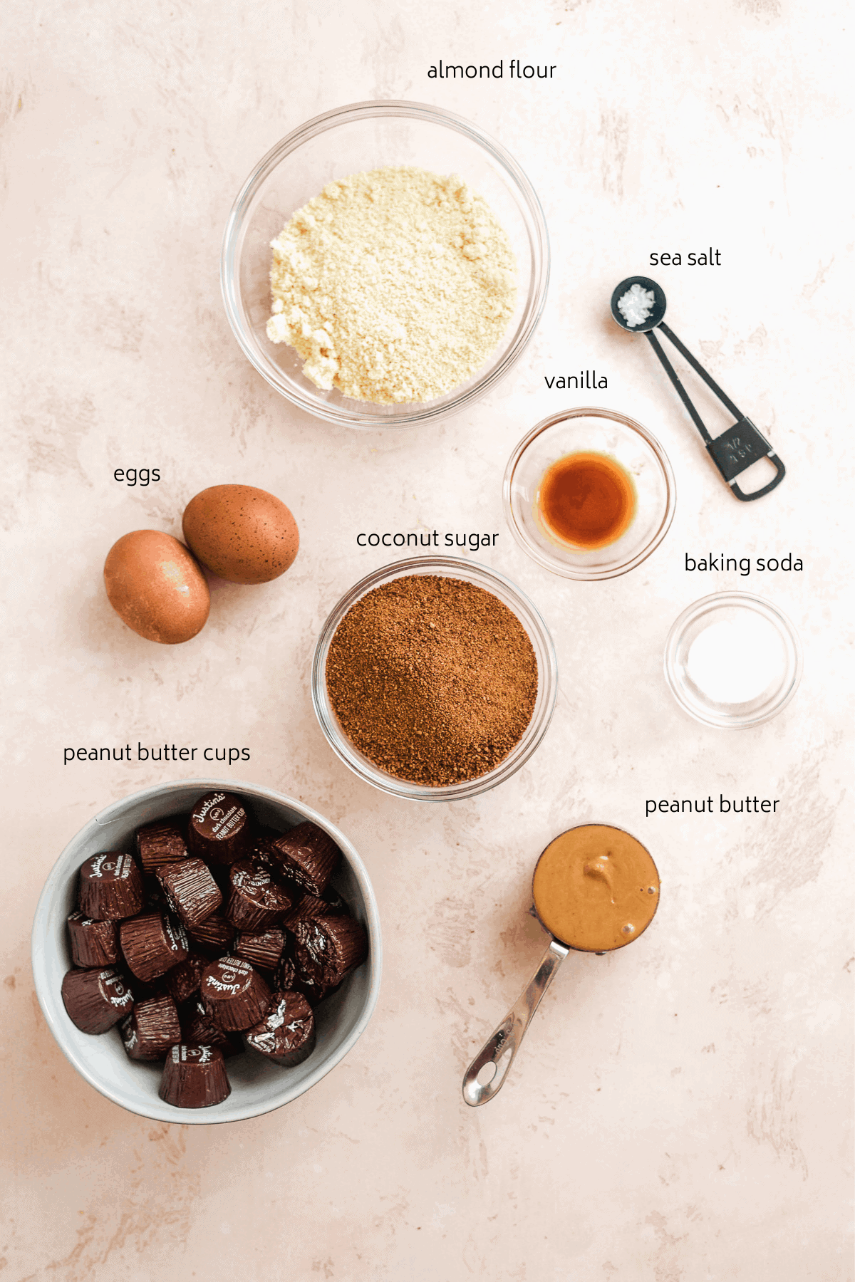 Image of peanut butter blossom cookie ingredients on a pink surface.