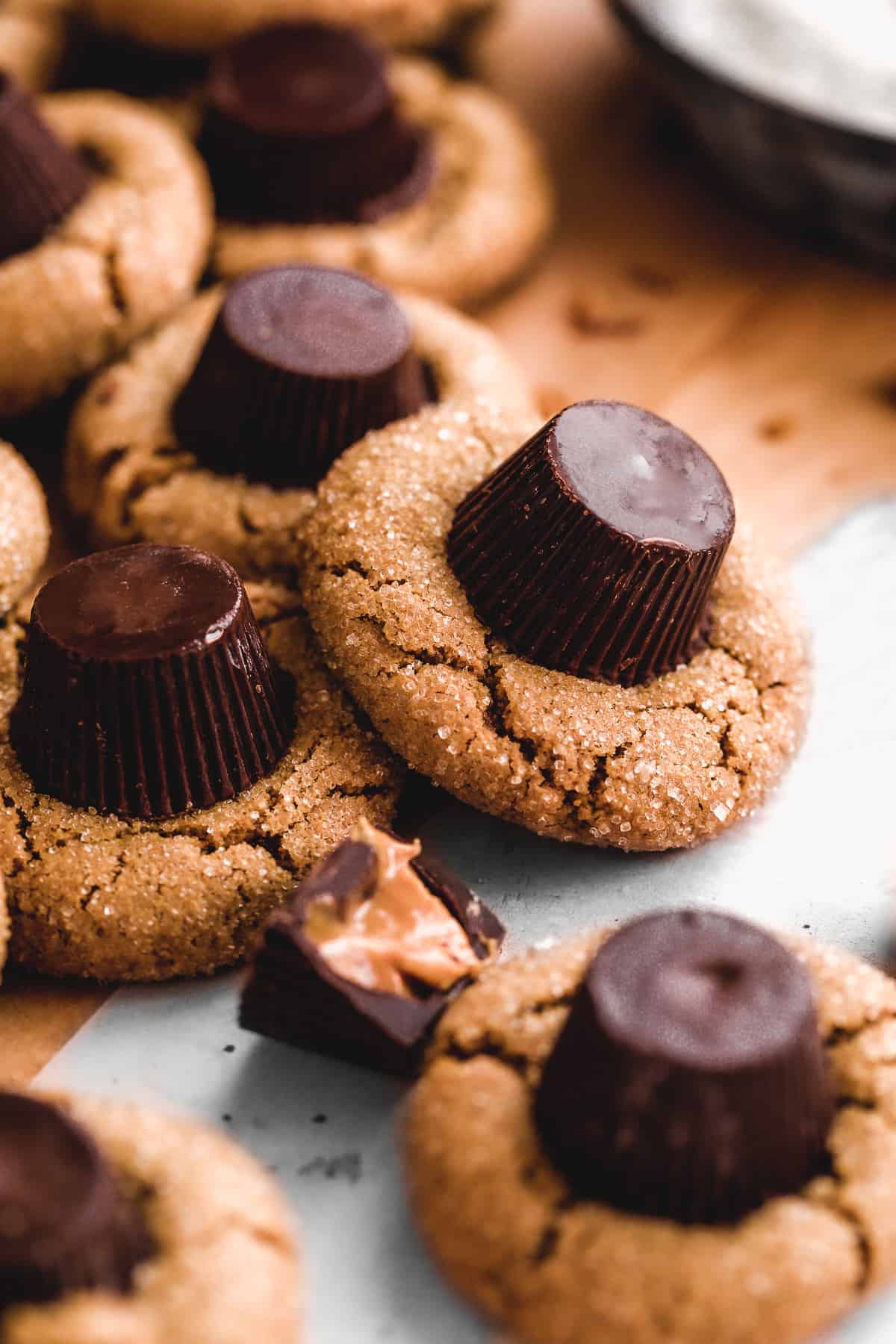 Peanut butter cookies with a peanut butter cup placed in the center scattered on a surface.