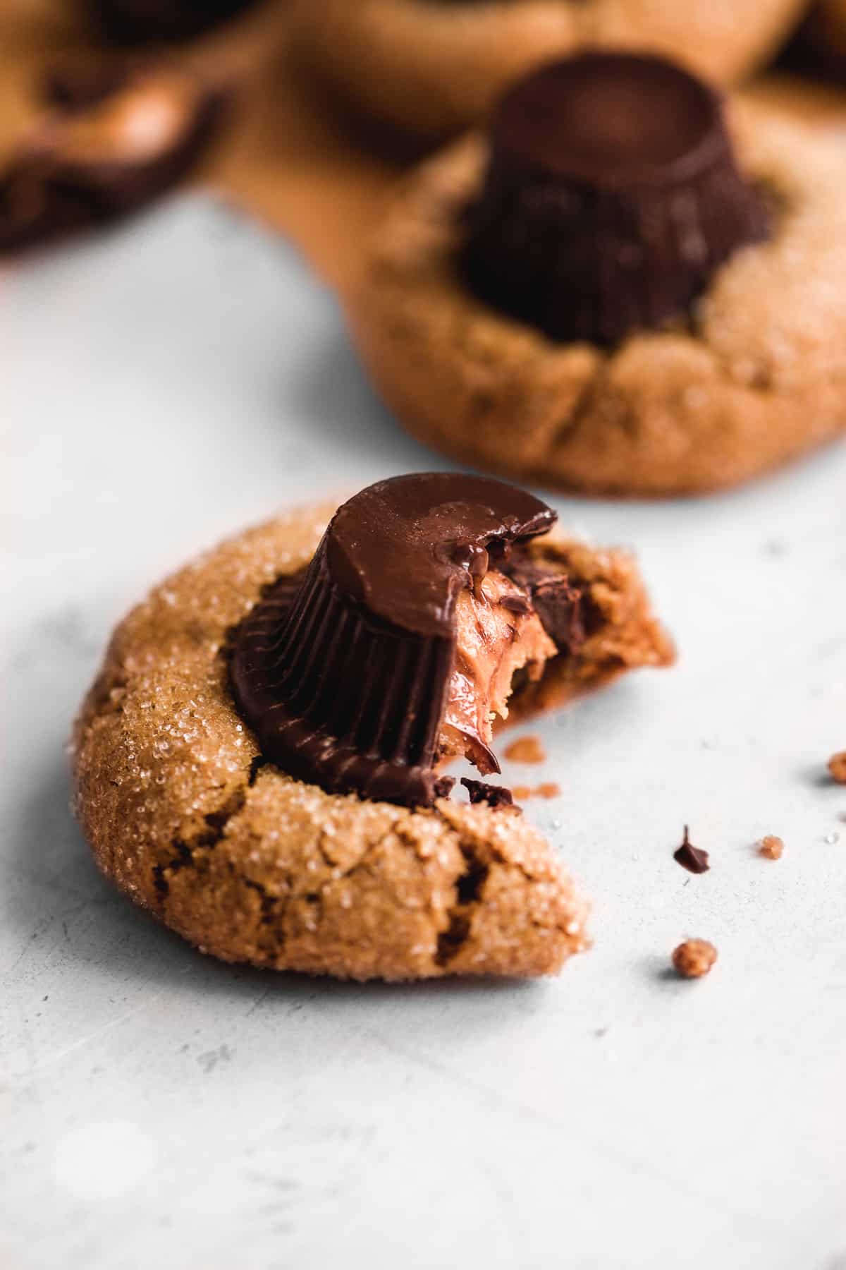 Peanut butter cookies with. peanut butter cup on top and a bite taken out of it.