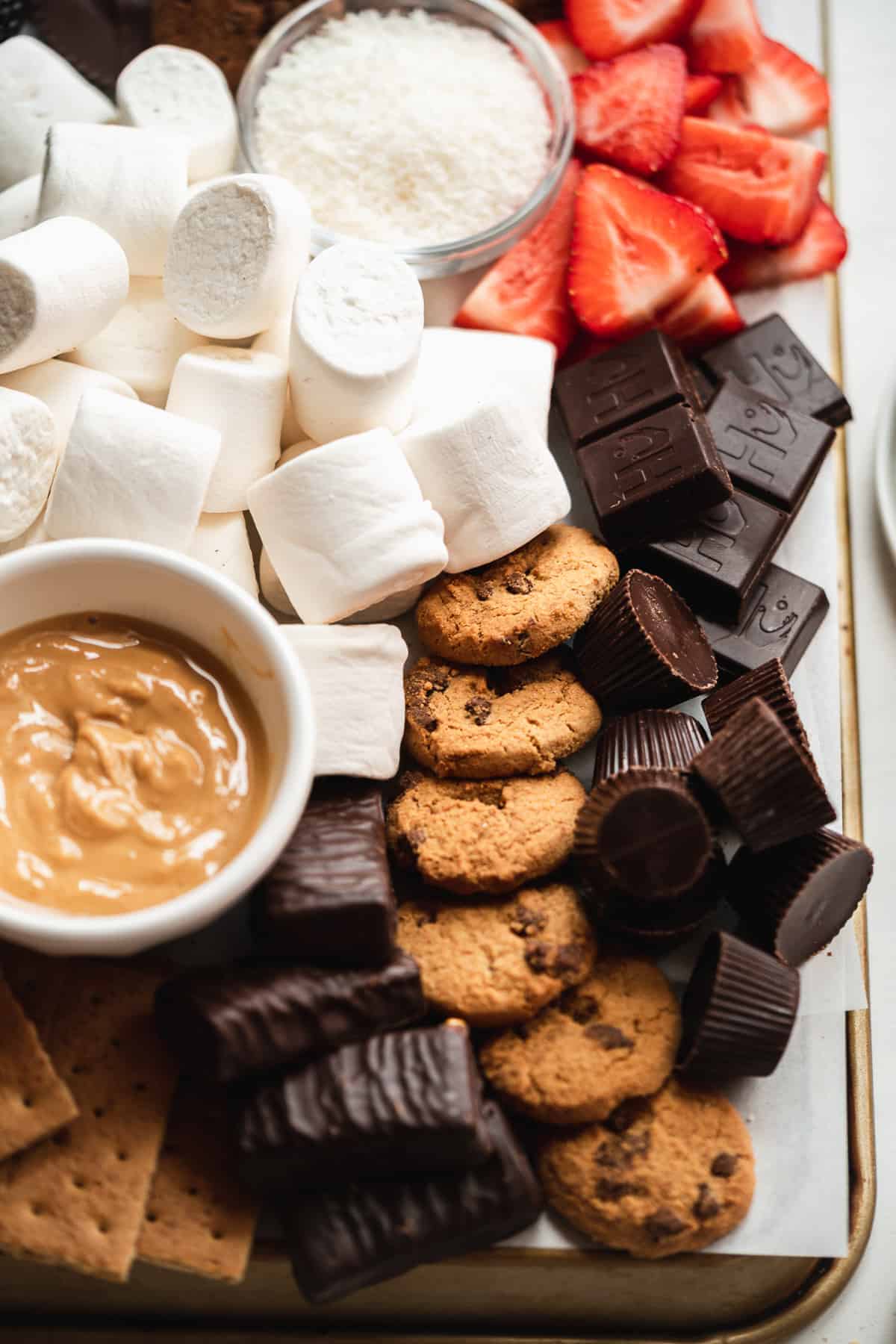 Board full of desserts like marshmallows and chocolate.