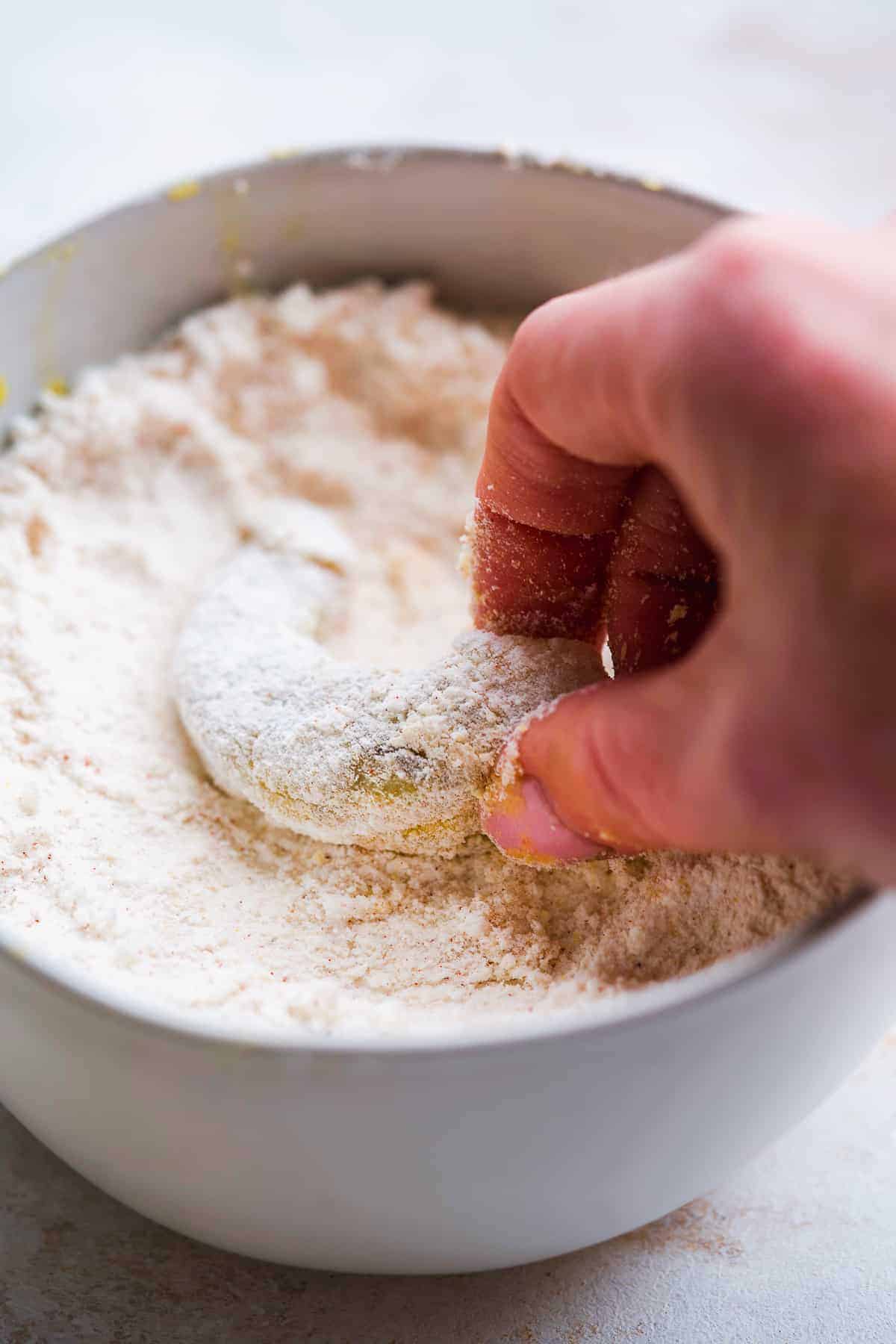 Shrimp being coated in breading.