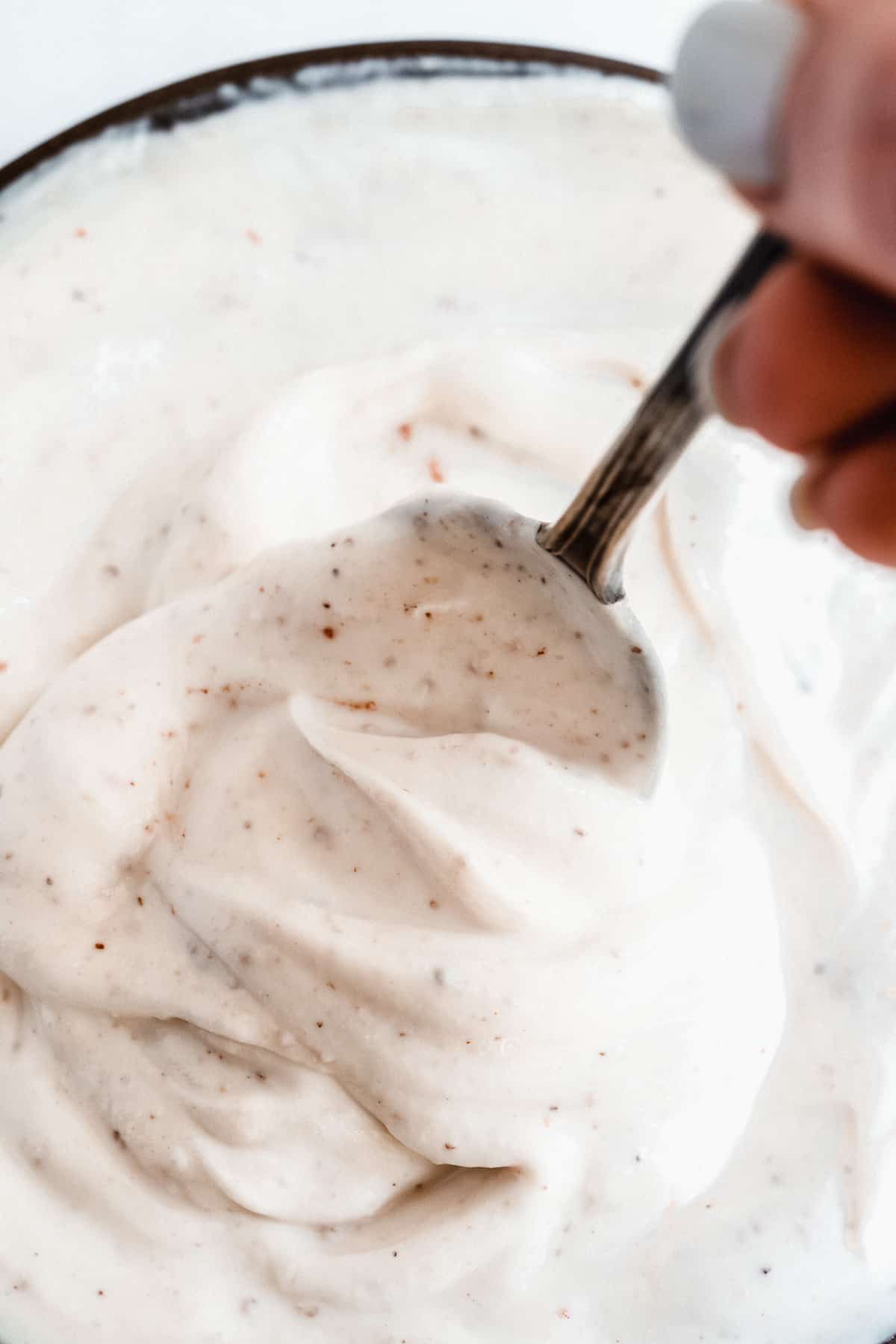 Spoon in greek yogurt dip with swirls.